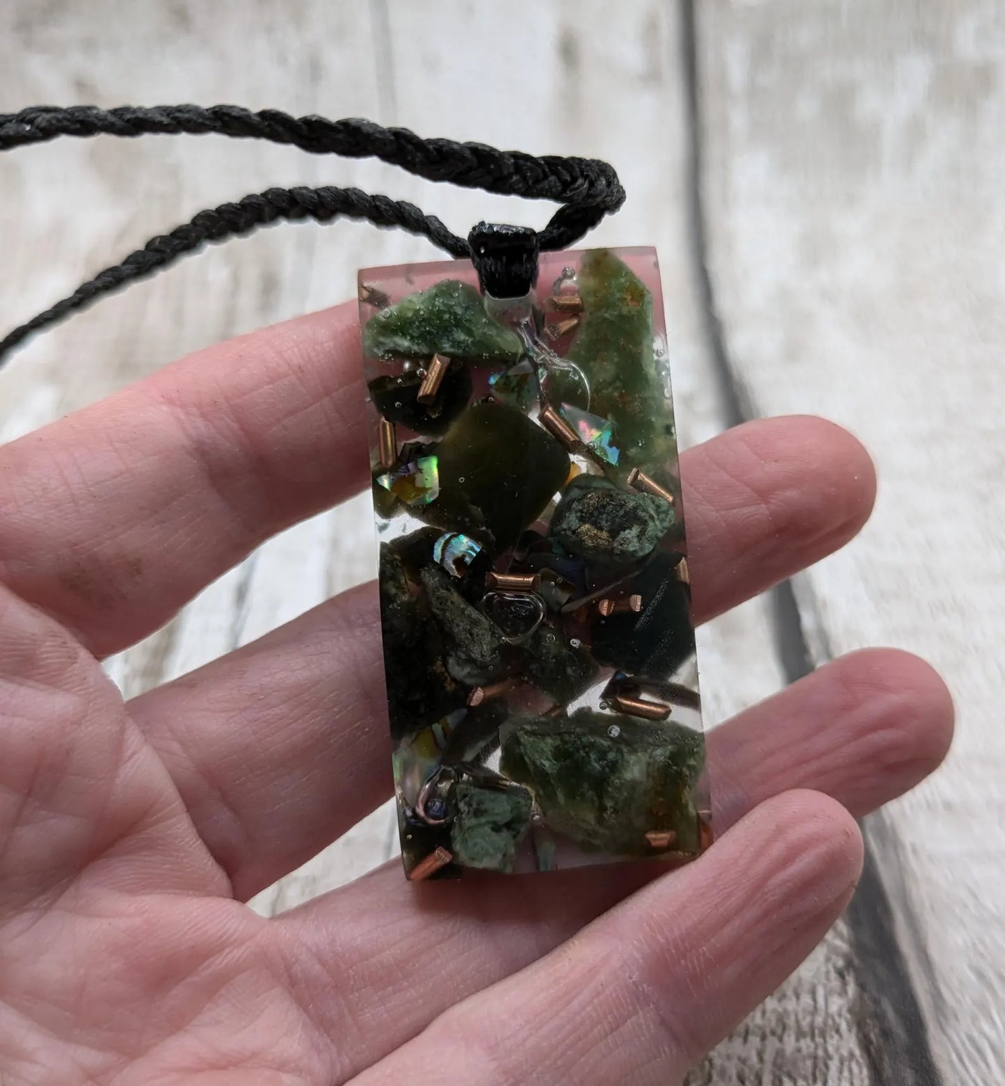 Mixed nephrite jade and copper in resin pendant.