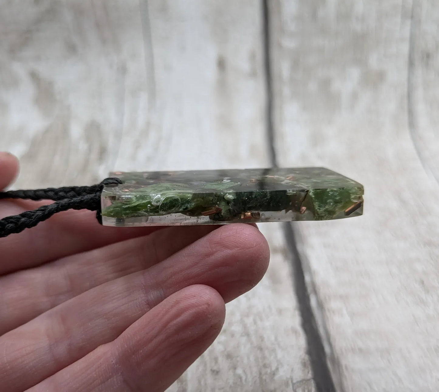 Mixed nephrite jade and copper in resin pendant.