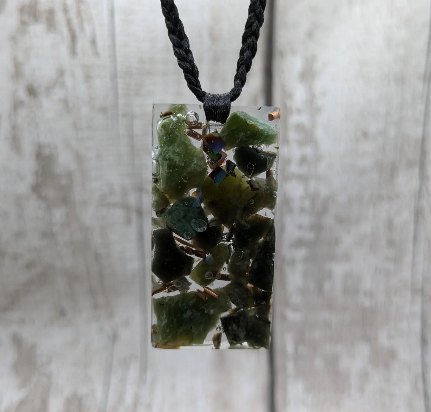 Mixed nephrite jade and copper in resin pendant.