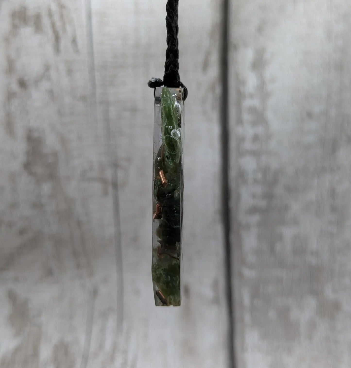 Mixed nephrite jade and copper in resin pendant.