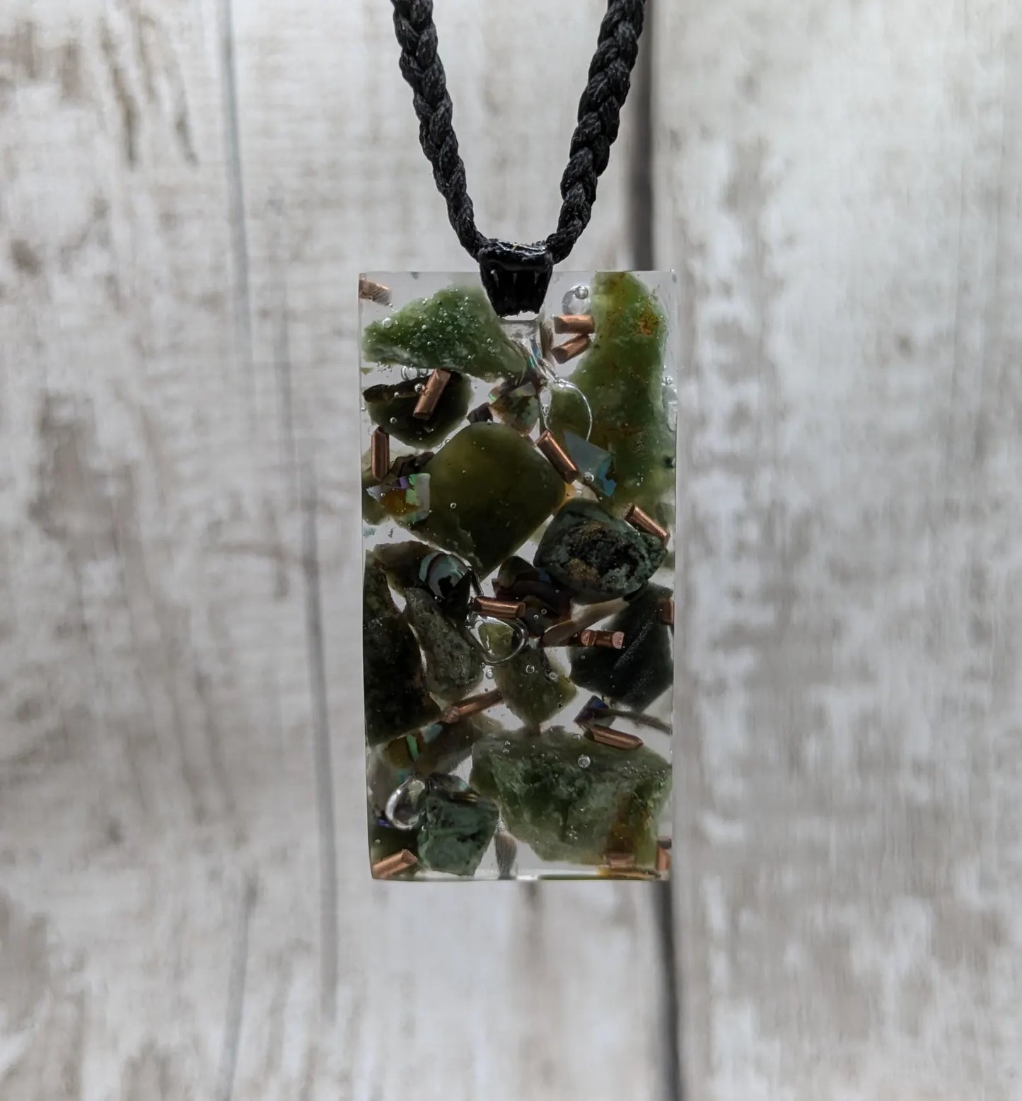 Mixed nephrite jade and copper in resin pendant.