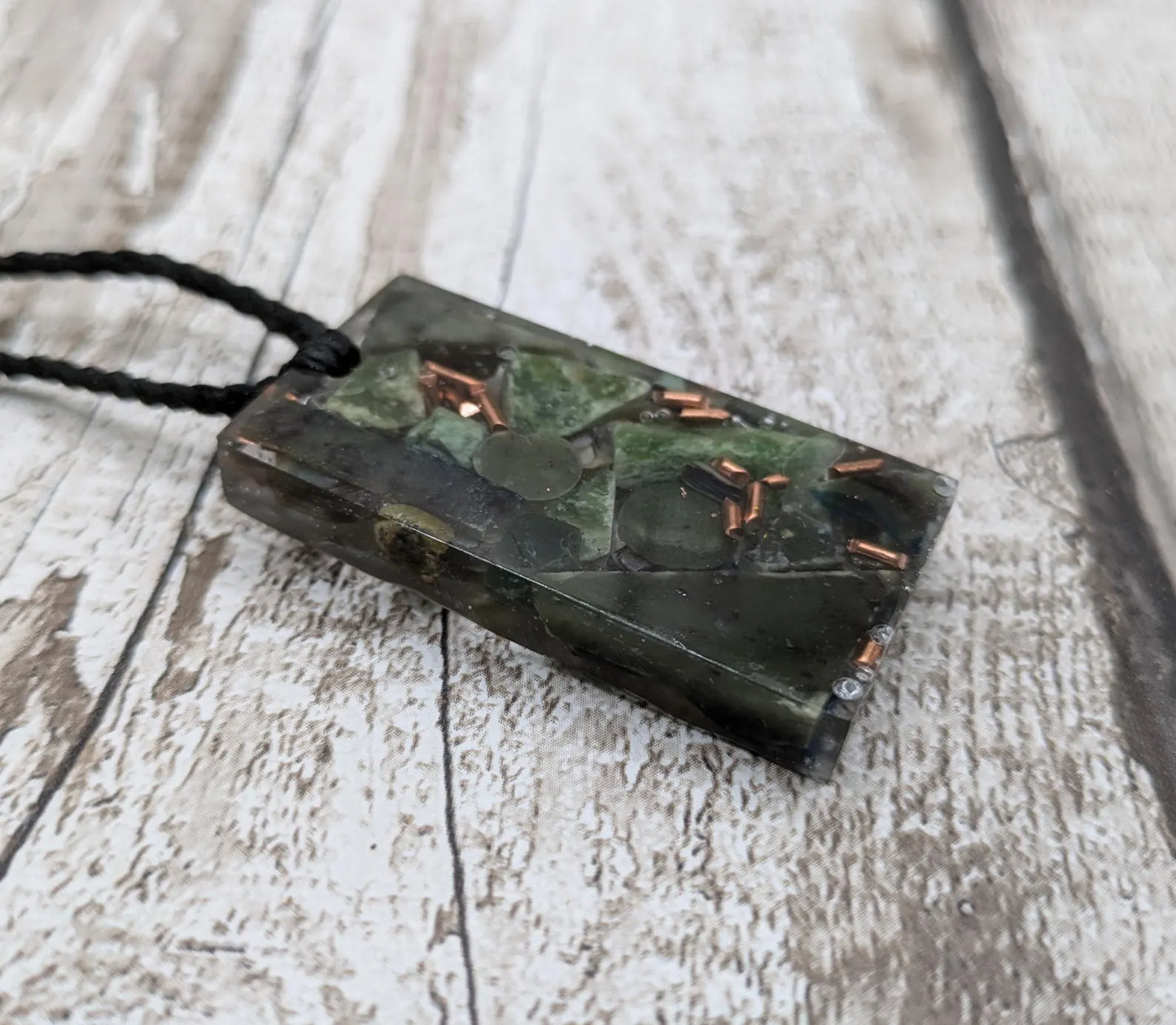 Mixed nephrite jade and copper pendant.