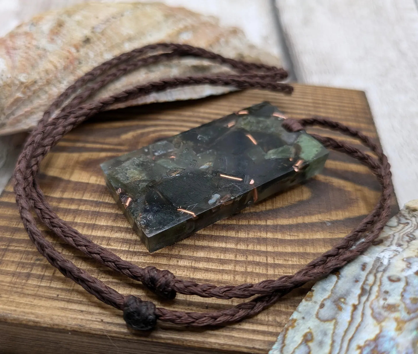 Mixed nephrite jade and copper in resin pendant.