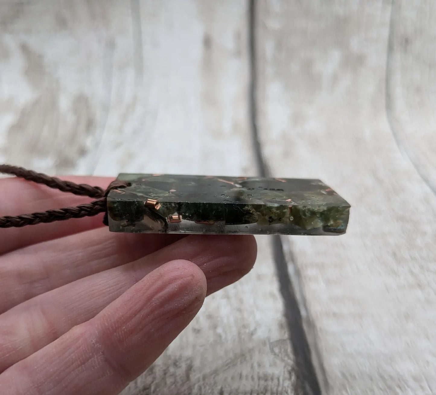 Mixed nephrite jade and copper in resin pendant.