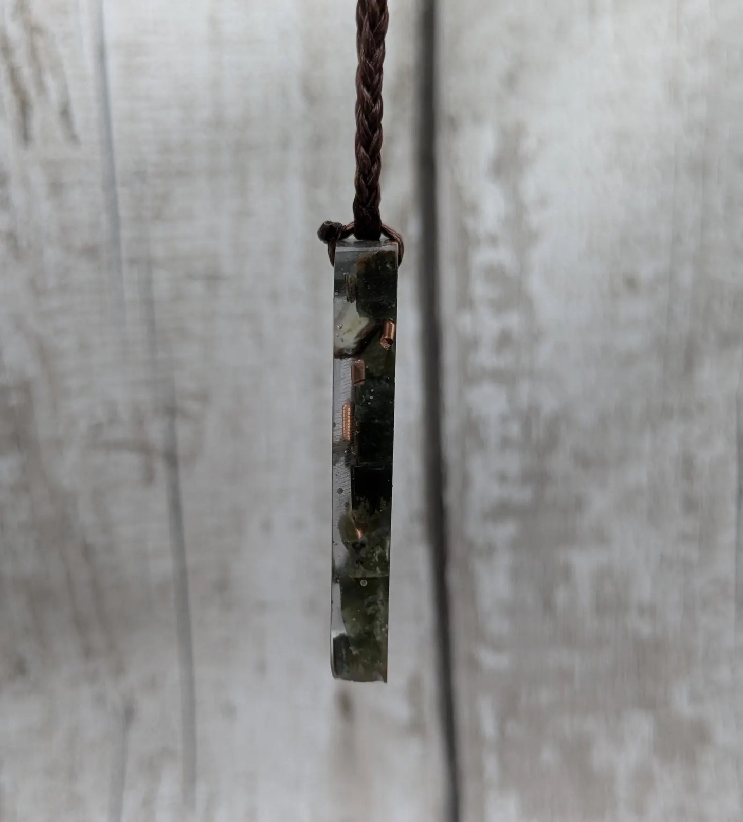 Mixed nephrite jade and copper in resin pendant.