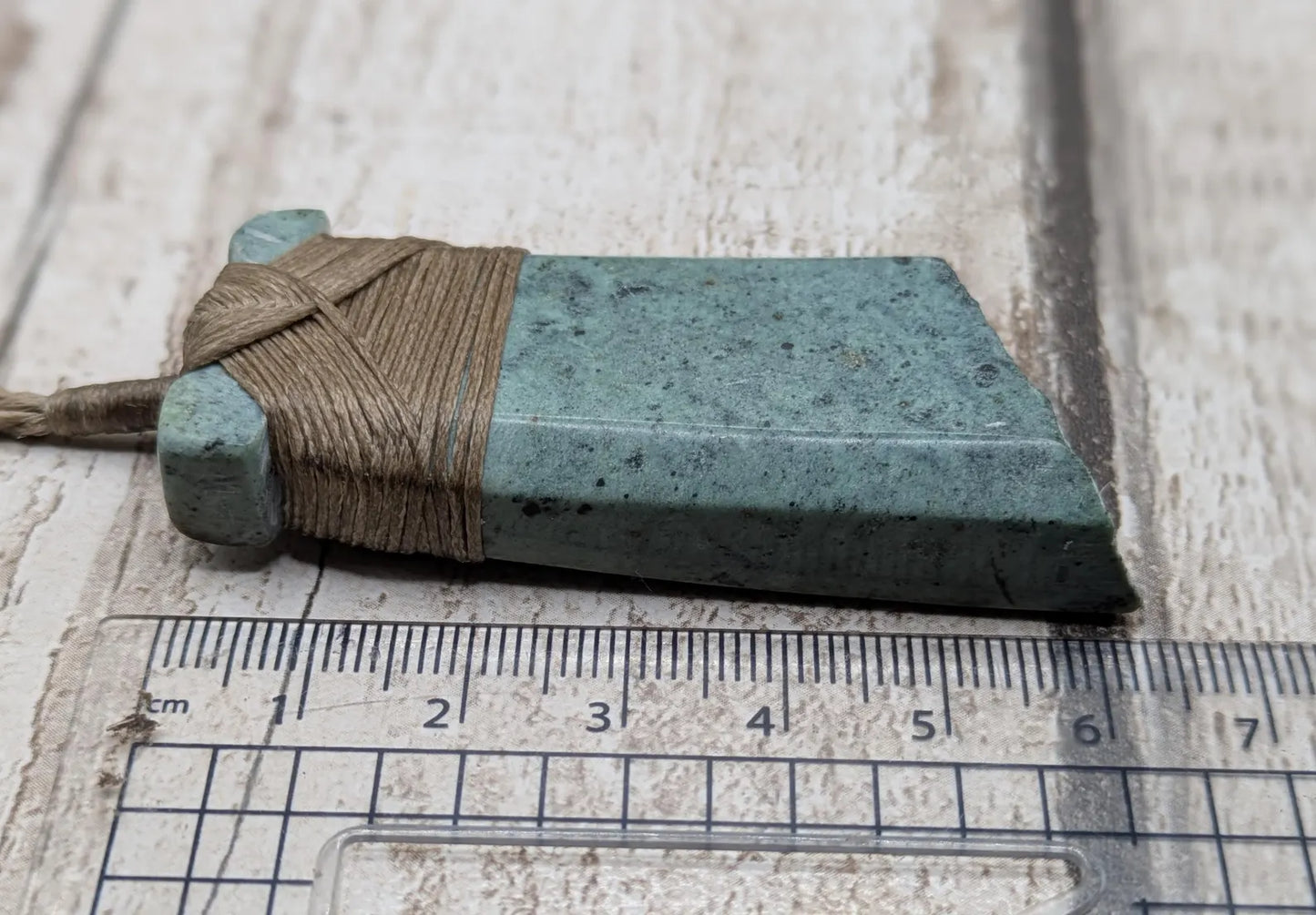 New Zealand Pounamu greenstone jade Hei Toki adze pendant with raw live edges.