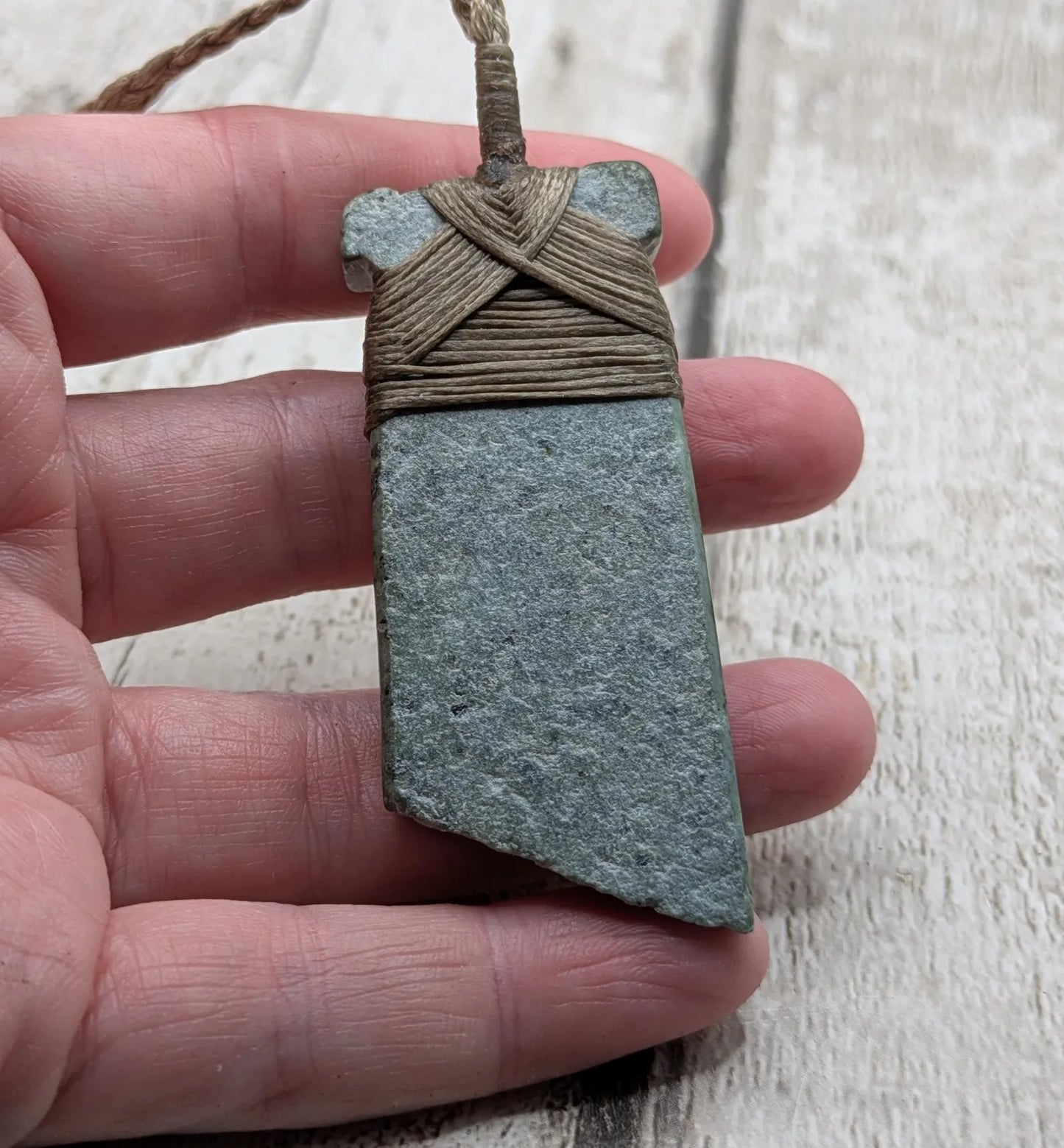 New Zealand Pounamu greenstone jade Hei Toki adze pendant with raw live edges.