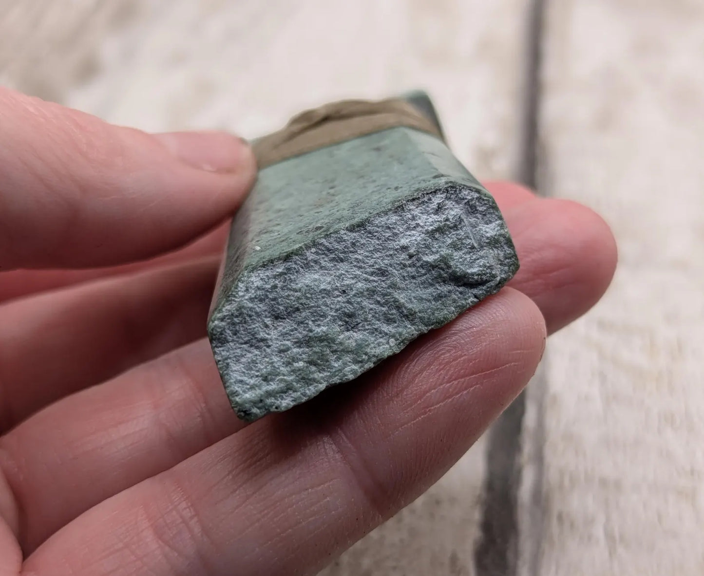 New Zealand Pounamu greenstone jade Hei Toki adze pendant with raw live edges.