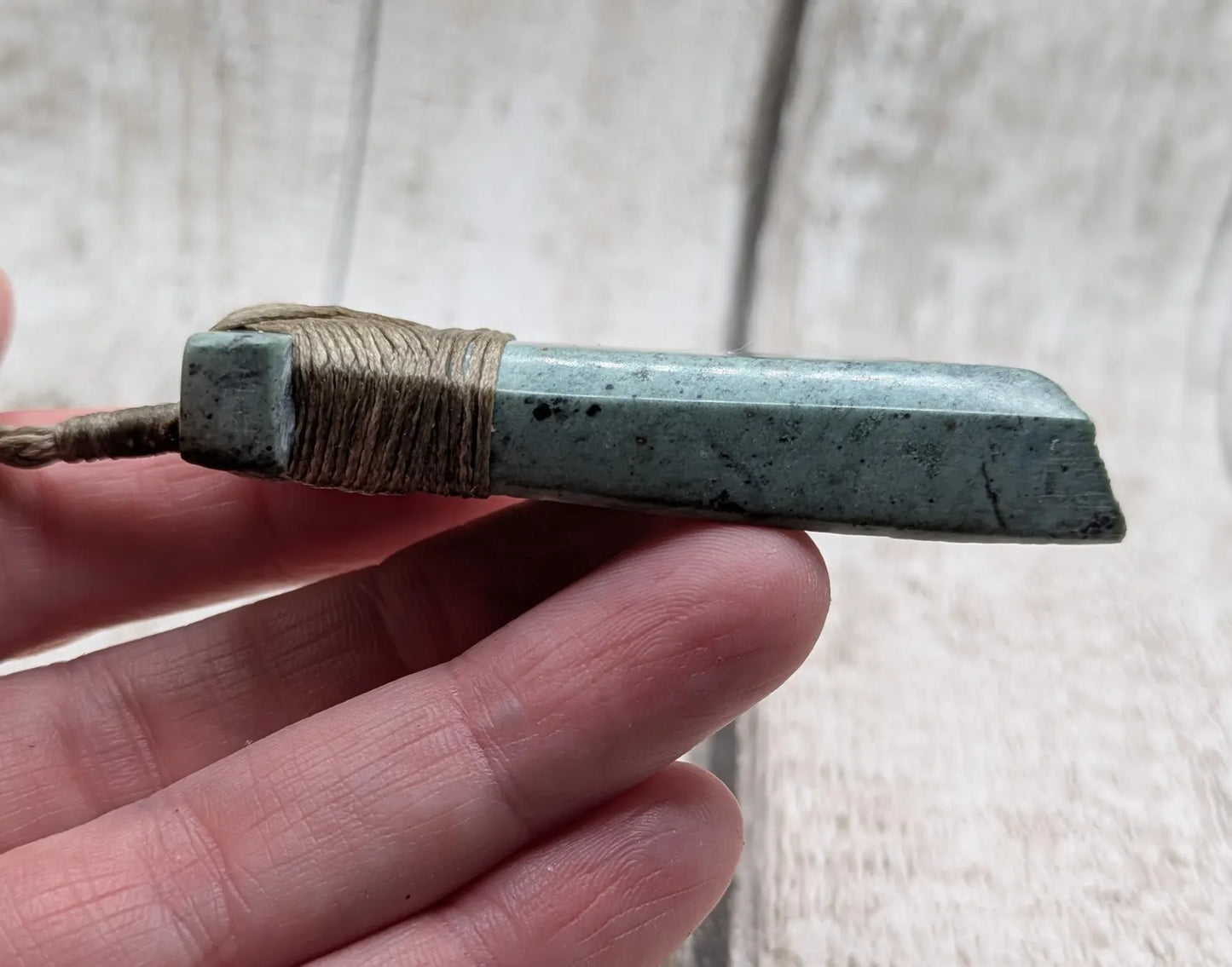 New Zealand Pounamu greenstone jade Hei Toki adze pendant with raw live edges.