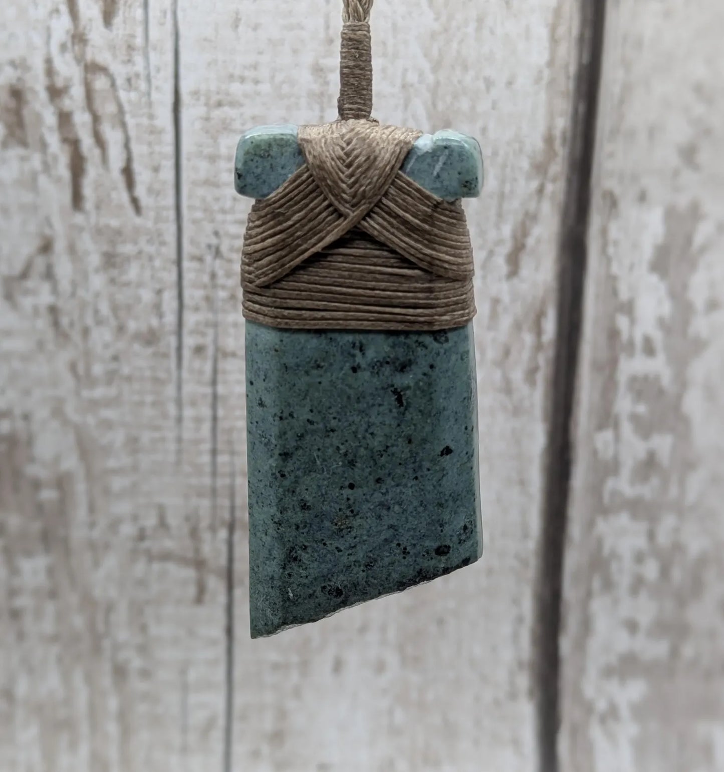 New Zealand Pounamu greenstone jade Hei Toki adze pendant with raw live edges.