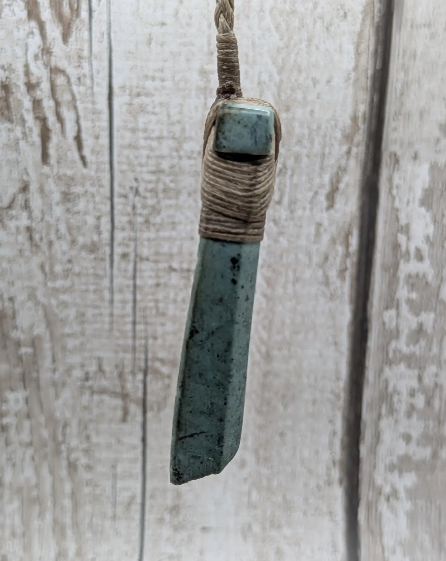 New Zealand Pounamu greenstone jade Hei Toki adze pendant with raw live edges.