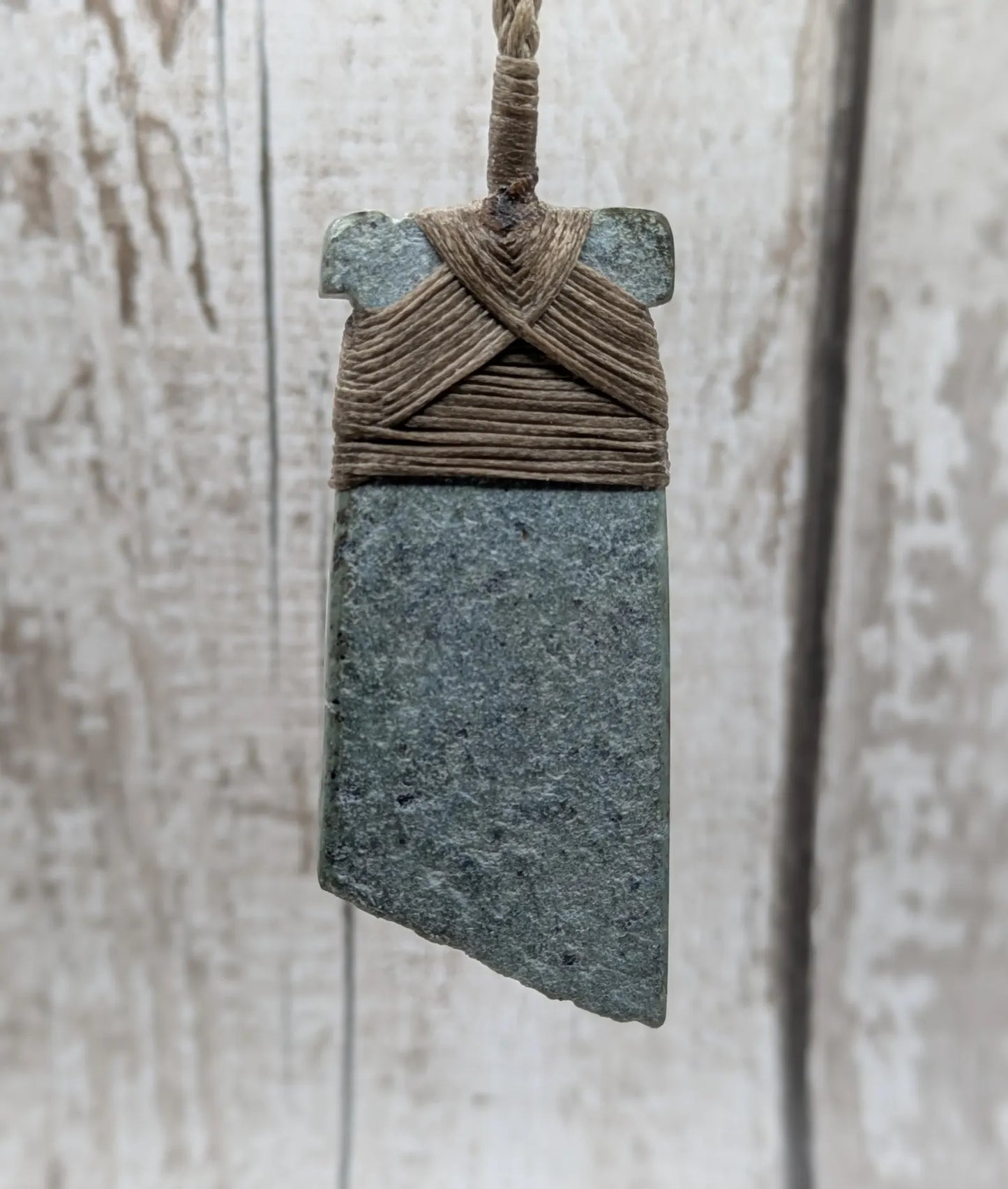 New Zealand Pounamu greenstone jade Hei Toki adze pendant with raw live edges.