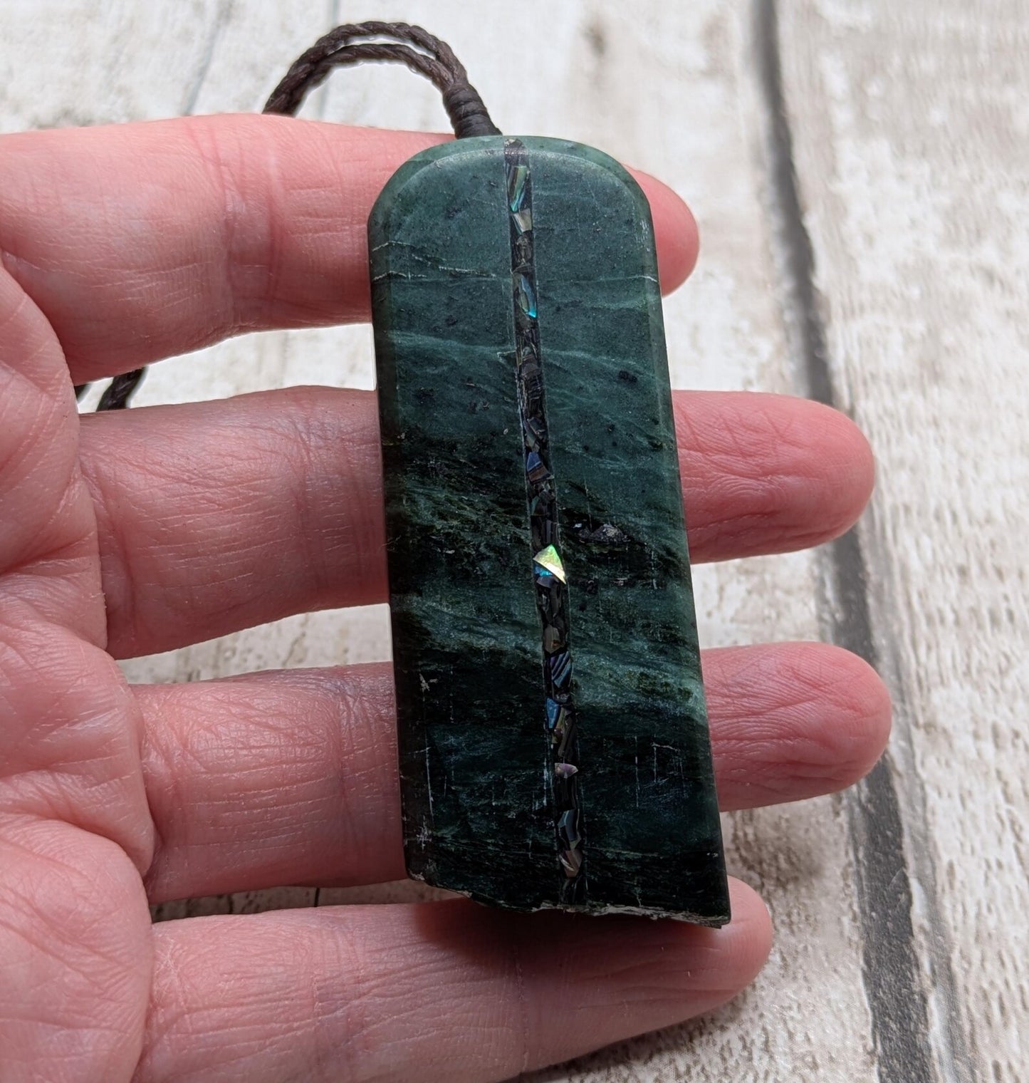 new Zealand pounamu serpentine with rainbownpāua inlay and raw edge.