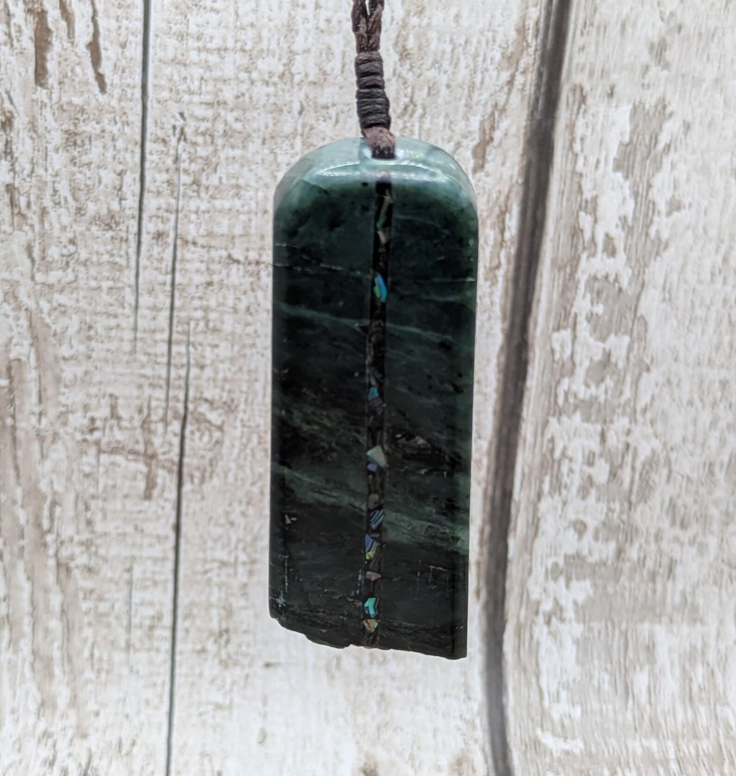 new Zealand pounamu serpentine with rainbownpāua inlay and raw edge.