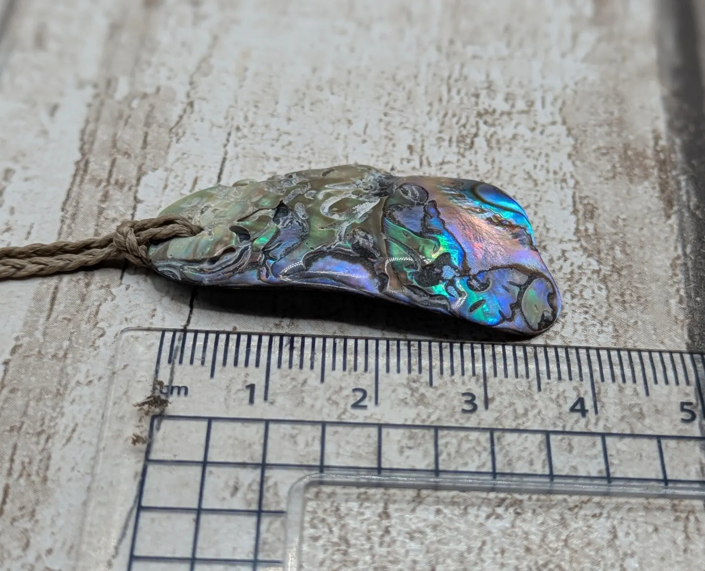 Naturally tumbled New Zealand rainbow Pāua abalone shell pendant