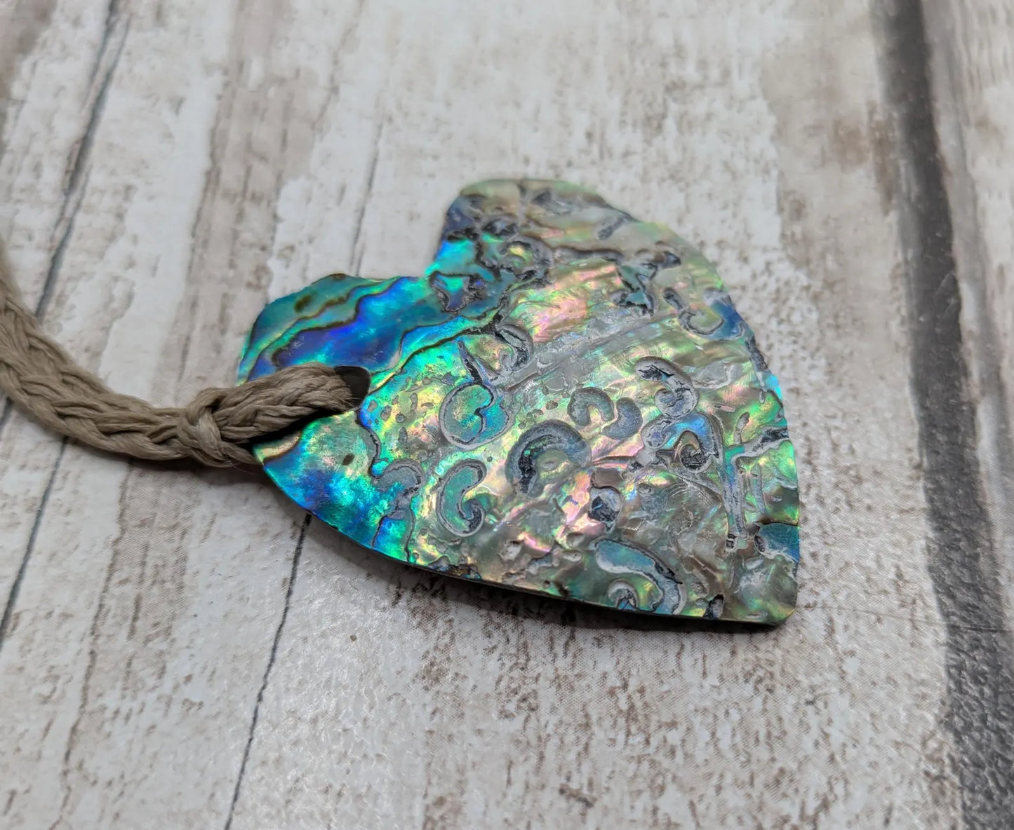 Hand carved New Zealand rainbow Pāua shell heart shaped pendant.