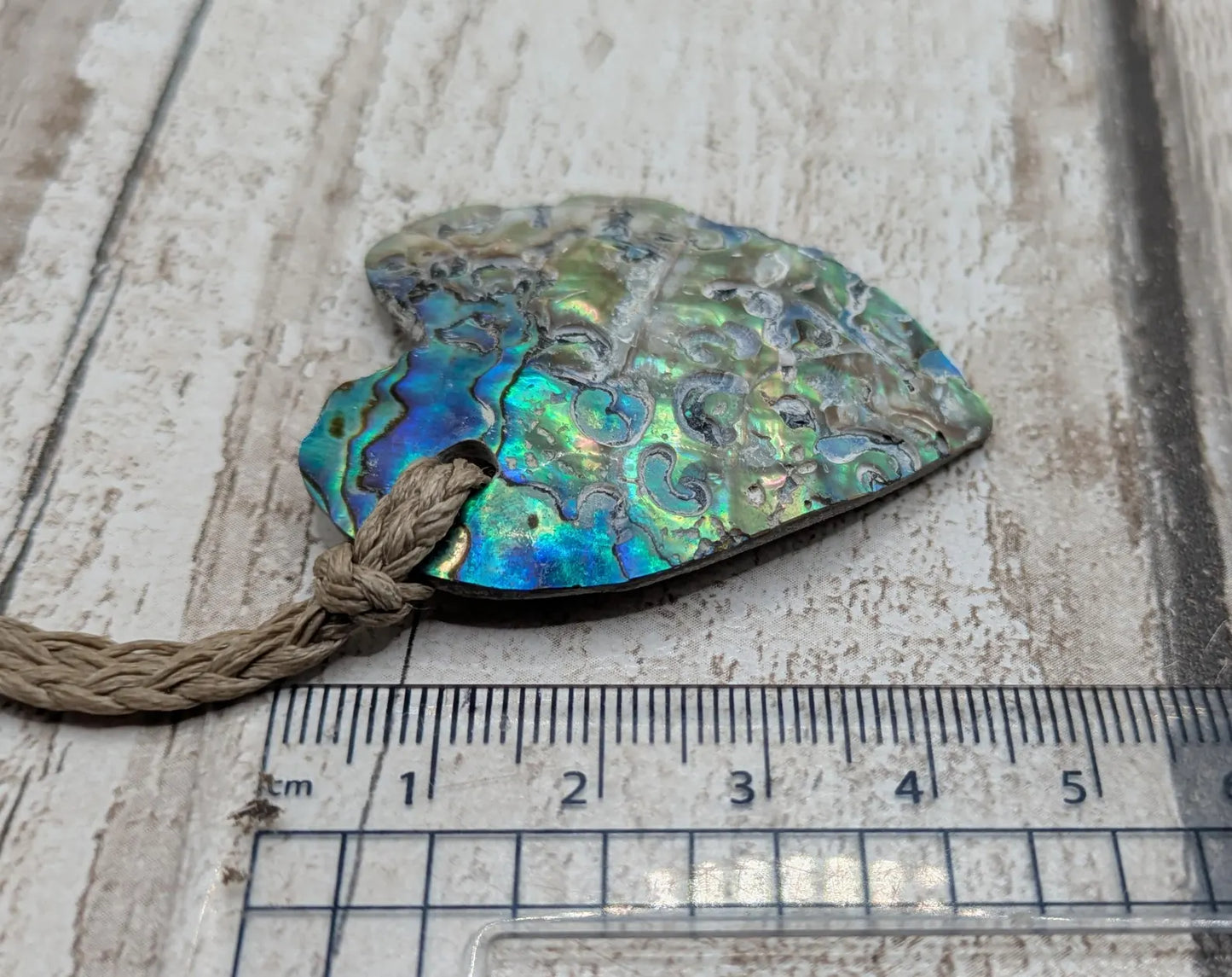 Hand carved New Zealand rainbow Pāua shell heart shaped pendant.