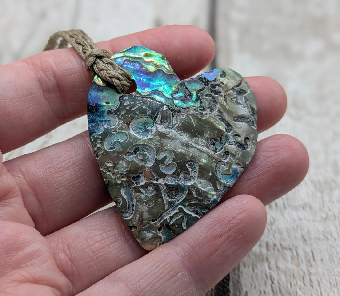Hand carved New Zealand rainbow Pāua shell heart shaped pendant.