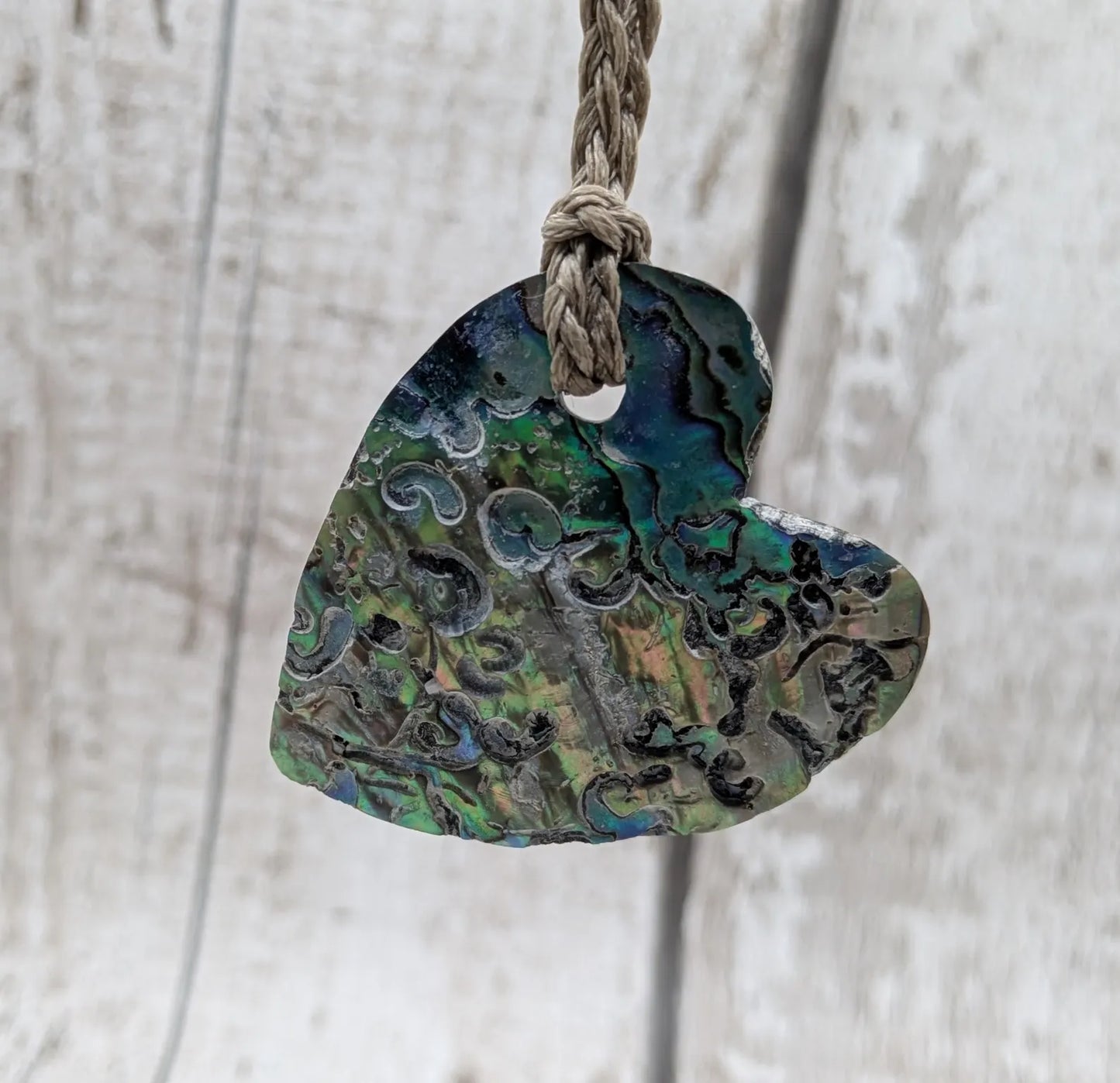 Hand carved New Zealand rainbow Pāua shell heart shaped pendant.
