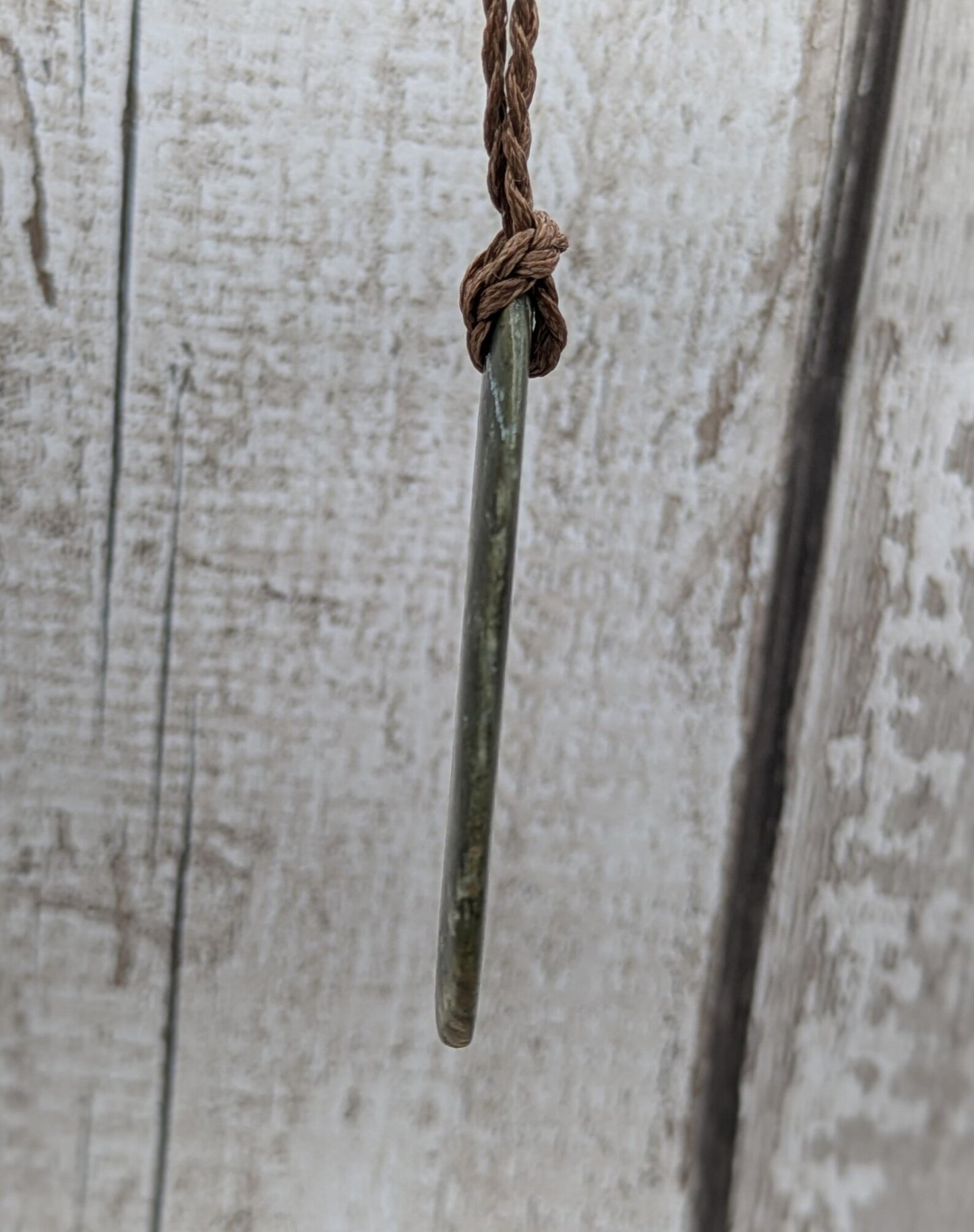 Tumbled polished New Zealand Pounamu greenstone pebble pendant.