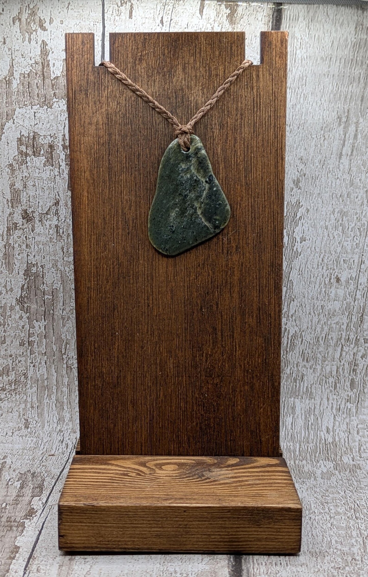 Tumbled polished New Zealand Pounamu greenstone pebble pendant.