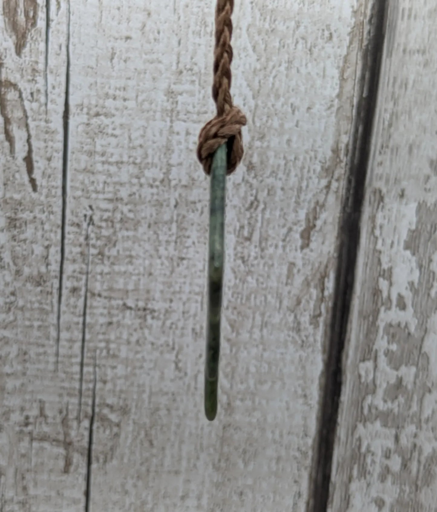 Tumble polished New Zealand Pounamu greenstone pebble pendant.