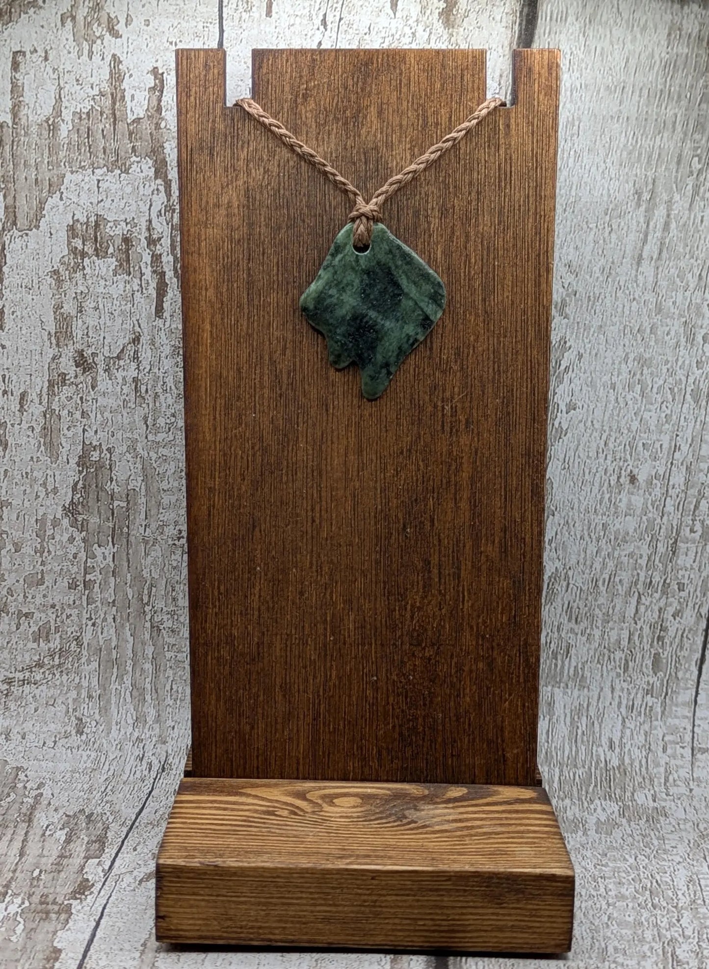 Tumble polished New Zealand Pounamu greenstone pebble pendant.