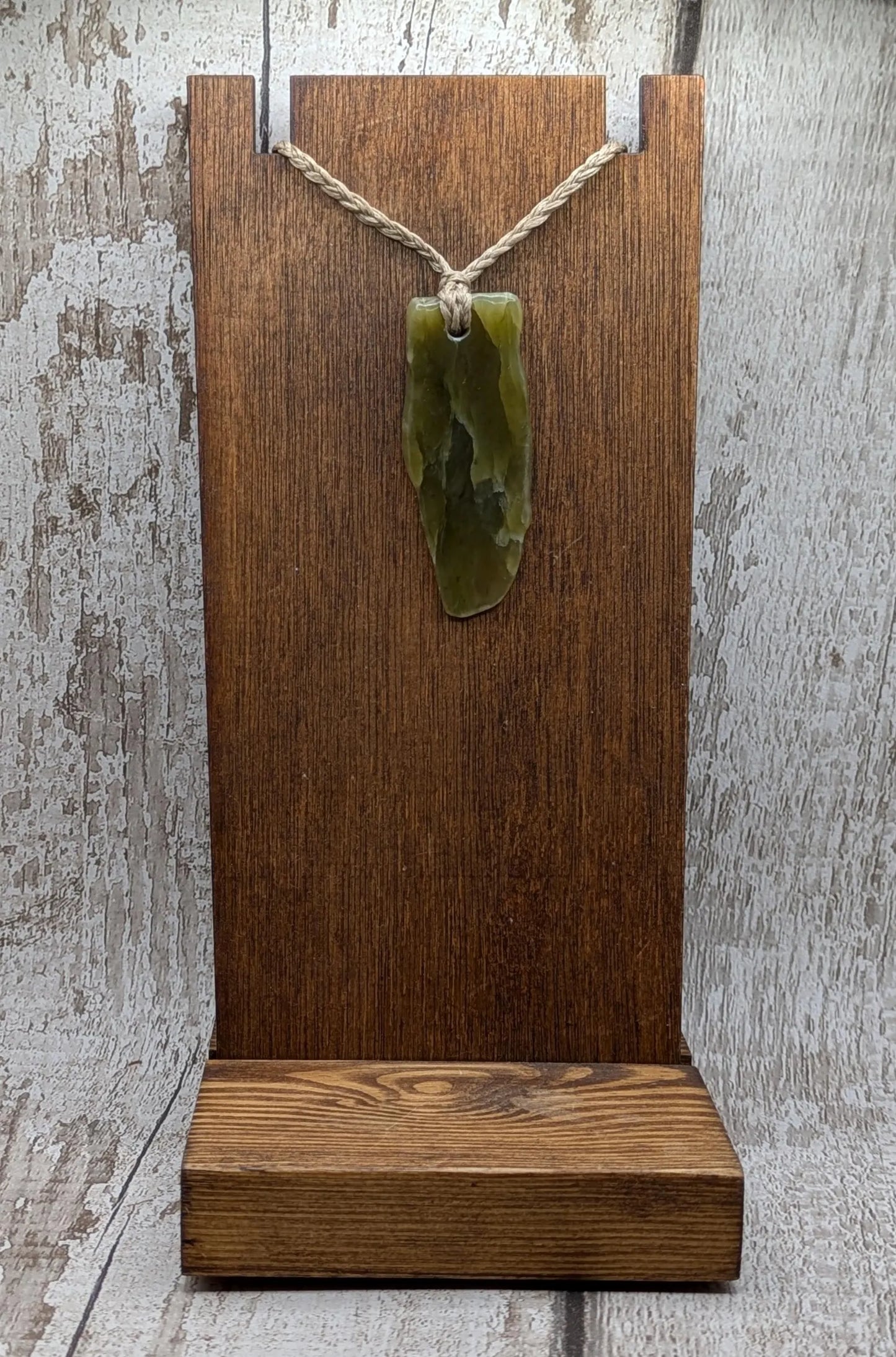 Tumble polished New Zealand Pounamu greenstone jade pendant.