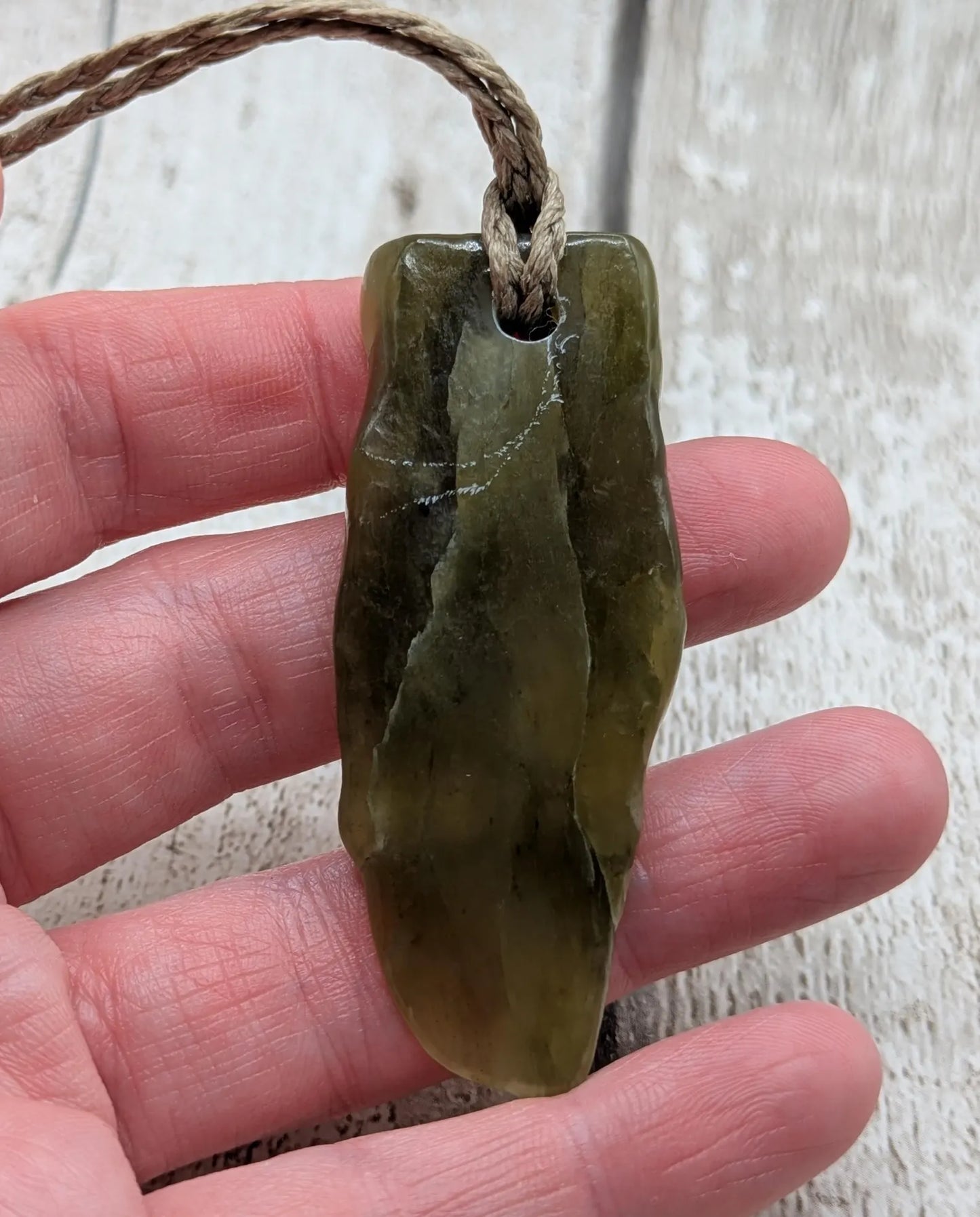 Tumble polished New Zealand Pounamu greenstone jade pendant.