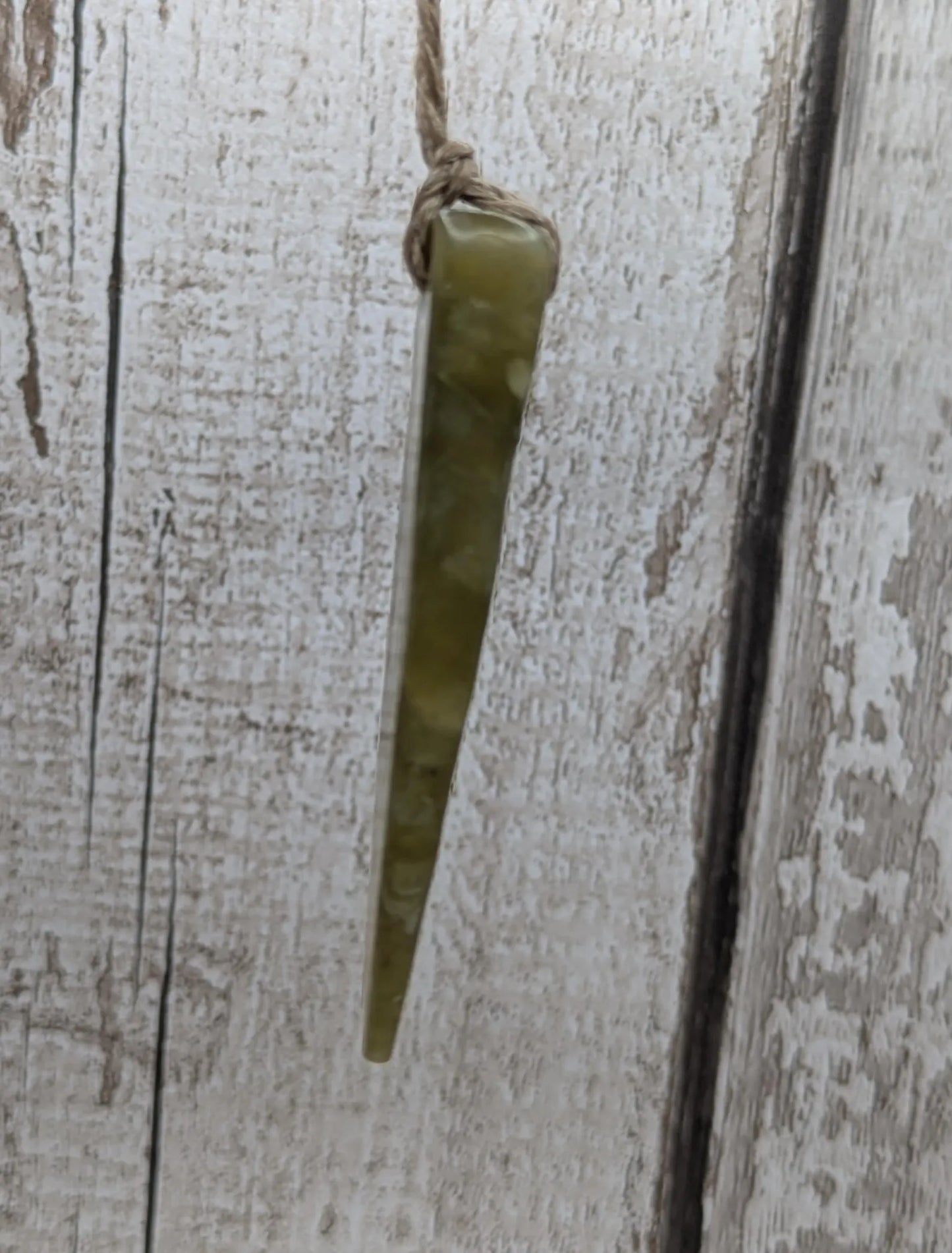 Tumble polished New Zealand Pounamu greenstone jade pendant.