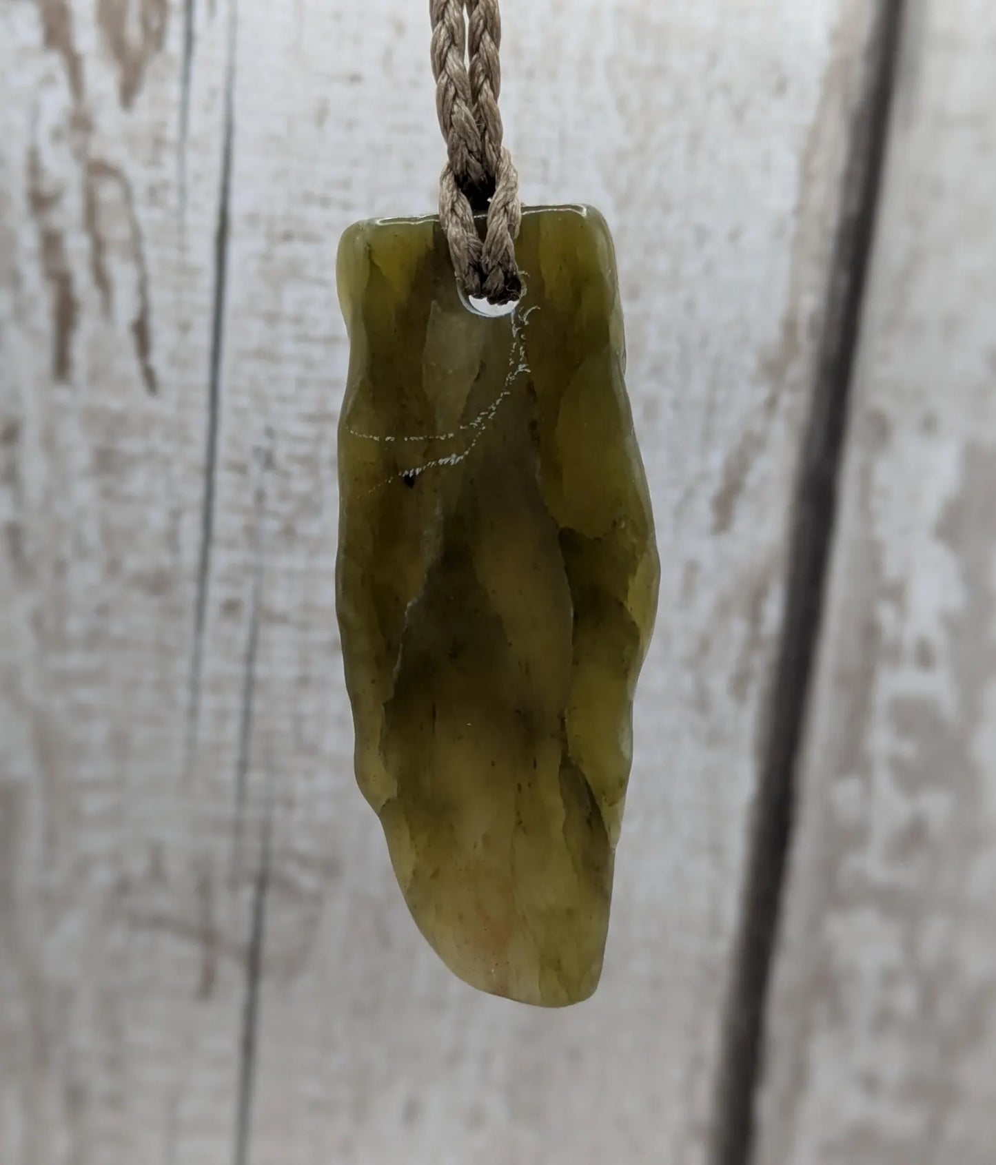 Tumble polished New Zealand Pounamu greenstone jade pendant.