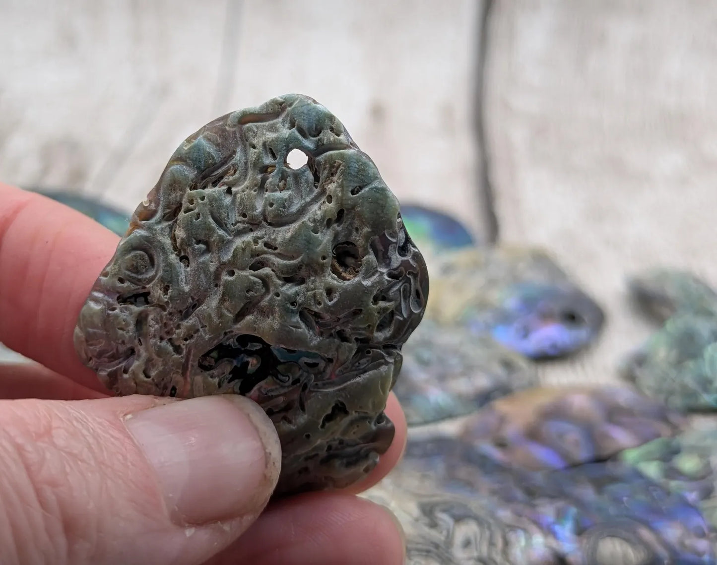 15 naturally tumbled New Zealand rainbow Pāua shell beads.