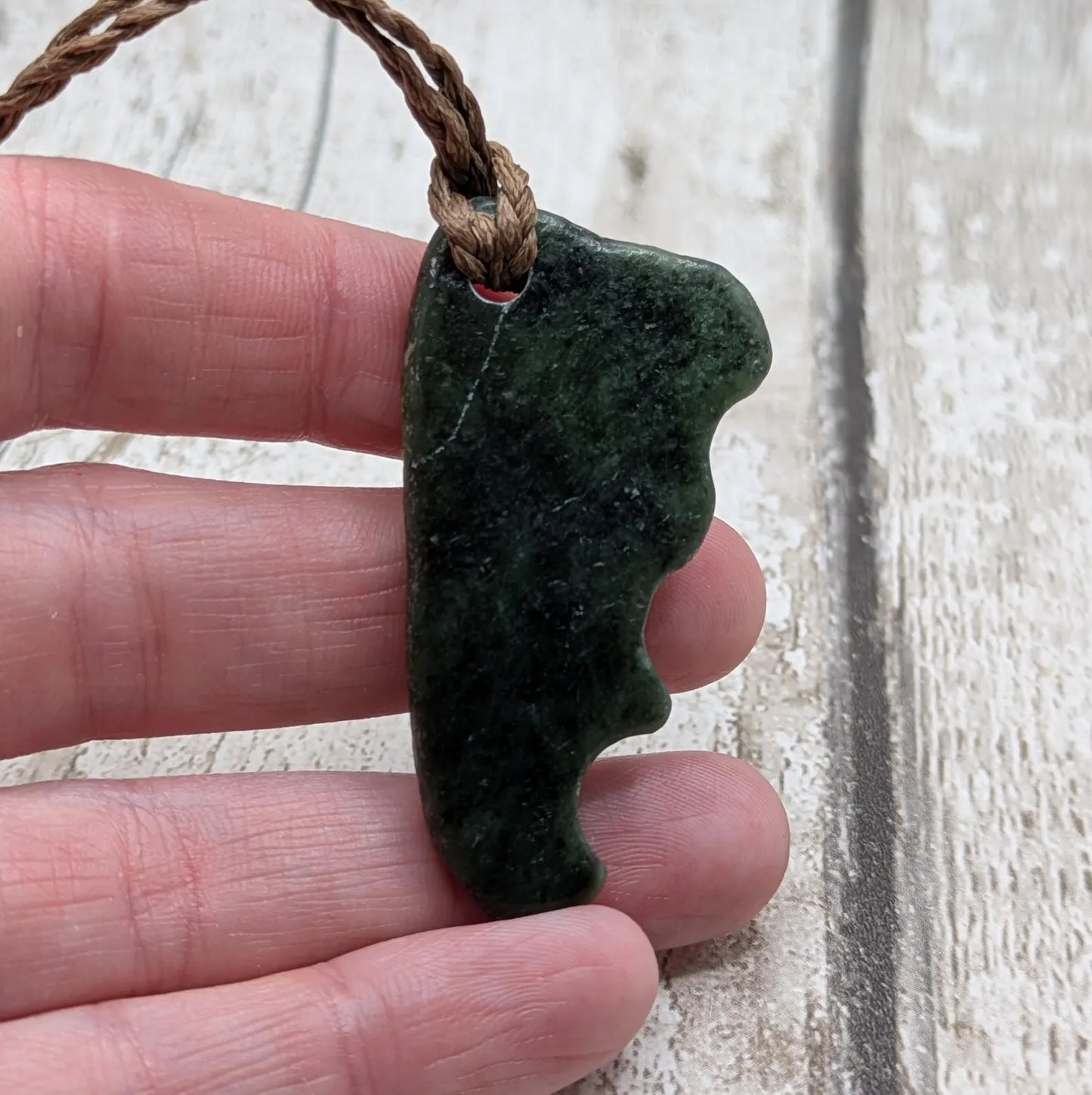 Tumble polished New Zealand Pounamu greenstone jade pendant.