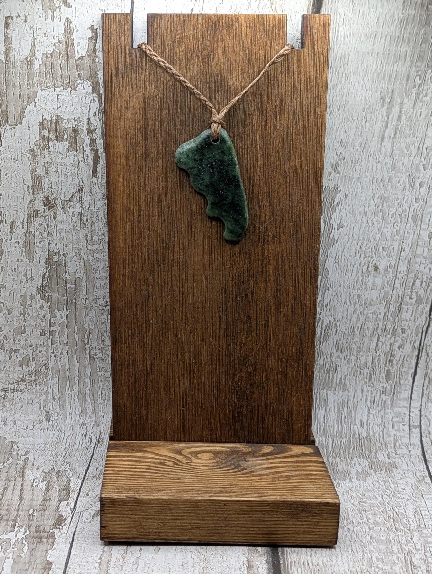 Tumble polished New Zealand Pounamu greenstone jade pendant.