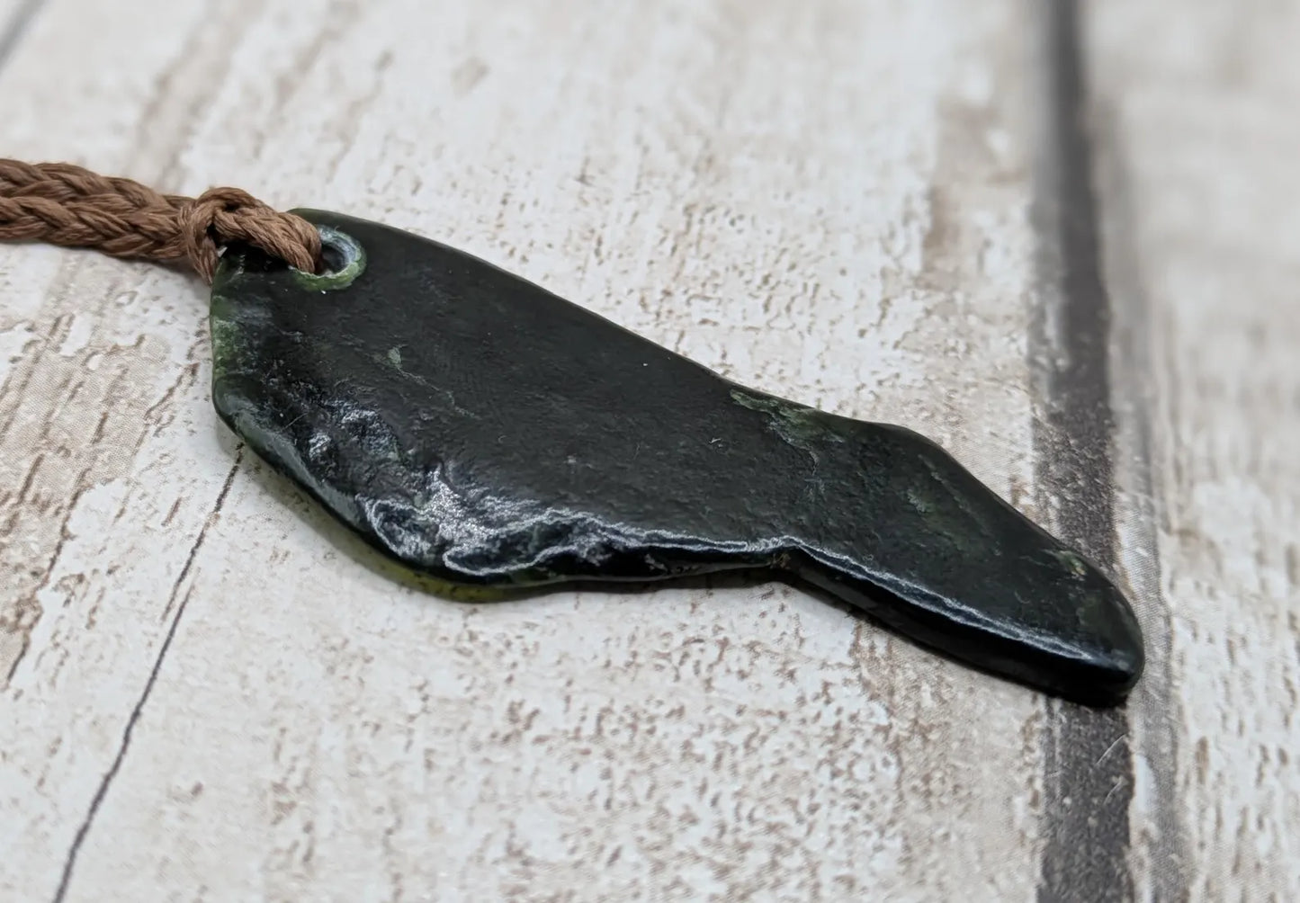Tumble polished New Zealand greenstone jade pendant.