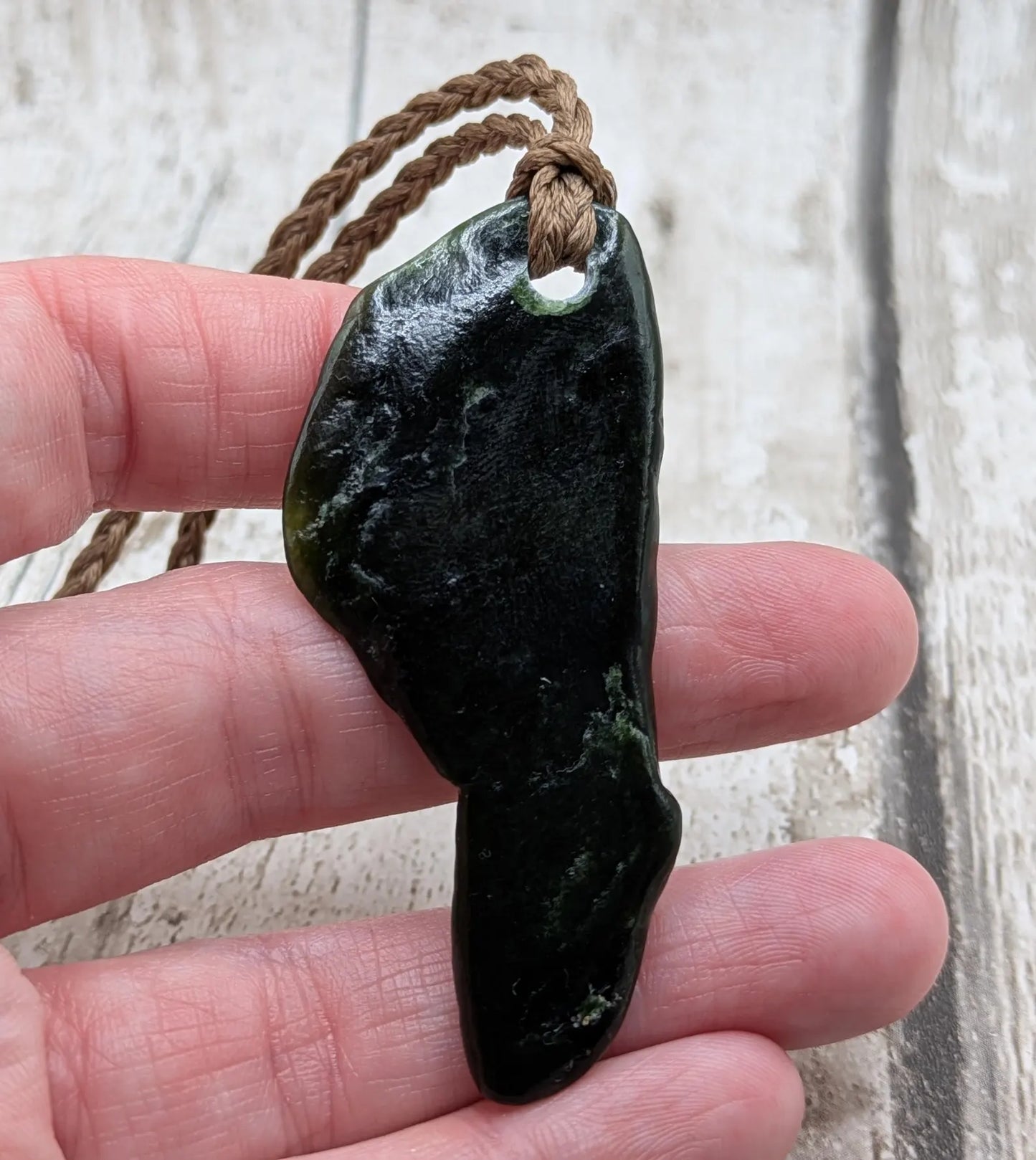 Tumble polished New Zealand greenstone jade pendant.