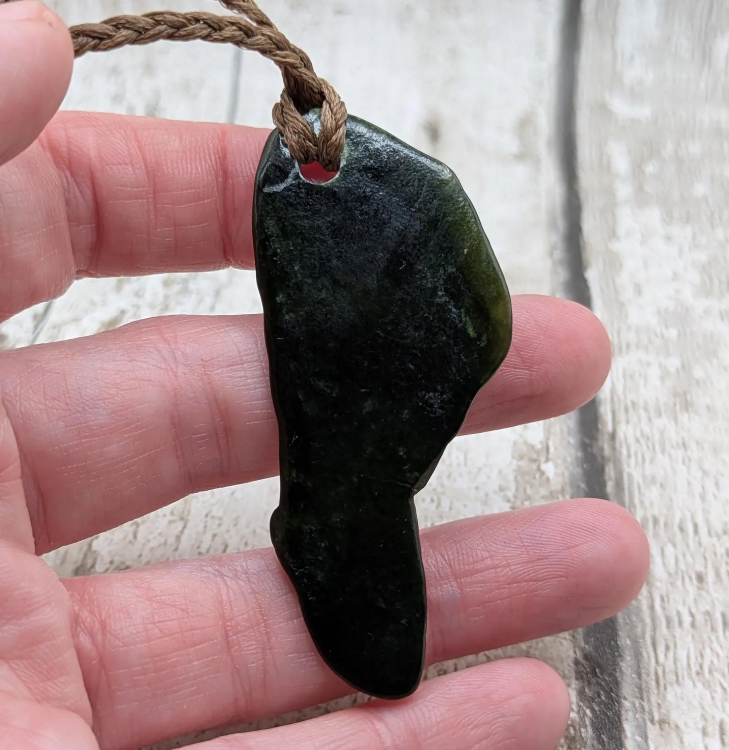 Tumble polished New Zealand greenstone jade pendant.