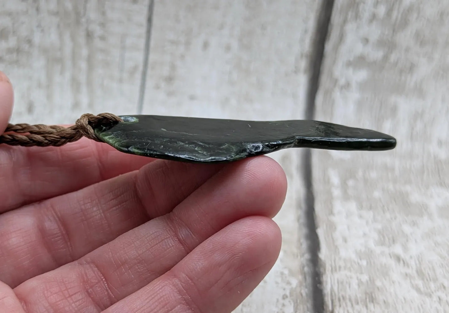 Tumble polished New Zealand greenstone jade pendant.