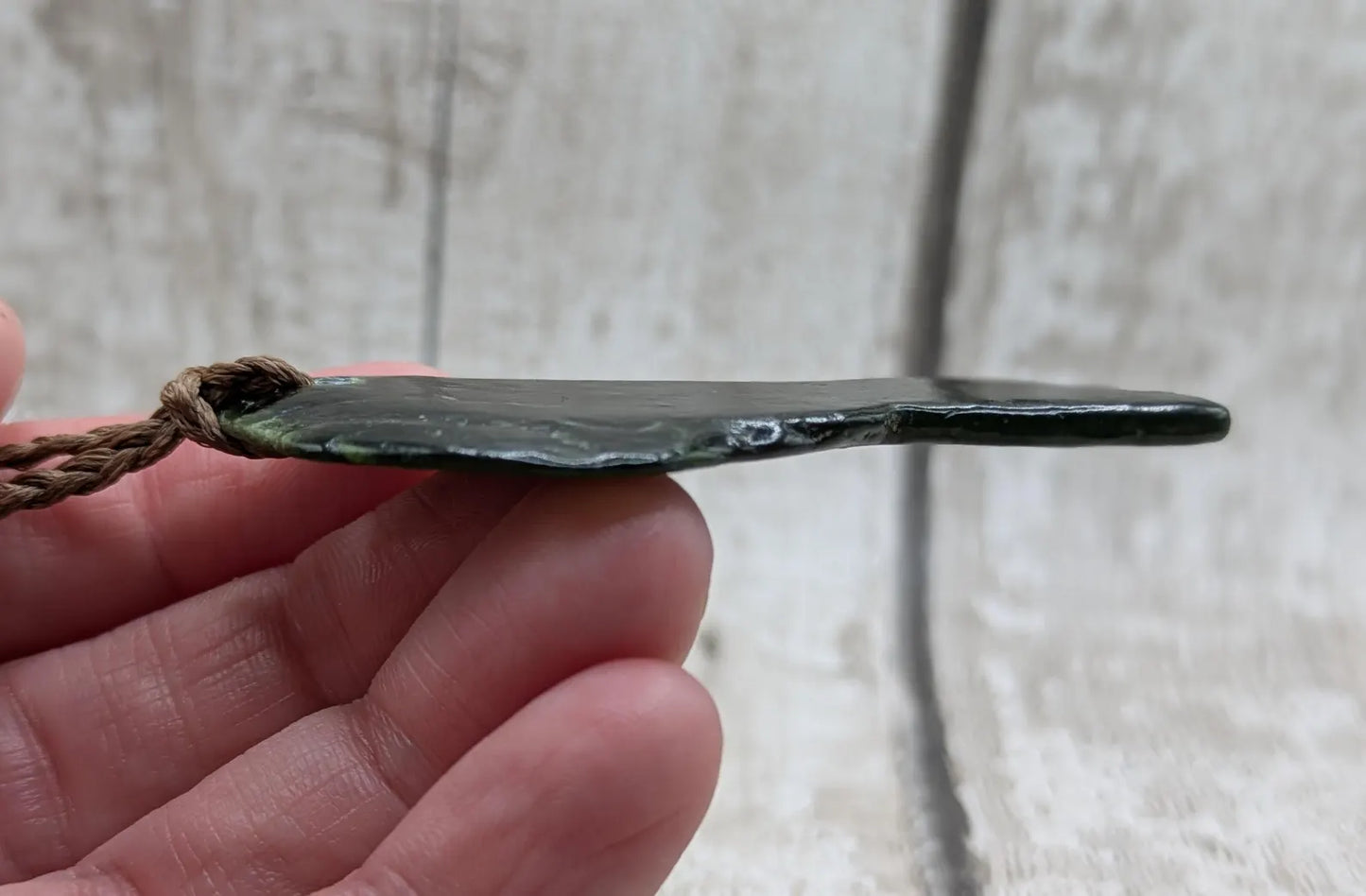 Tumble polished New Zealand greenstone jade pendant.