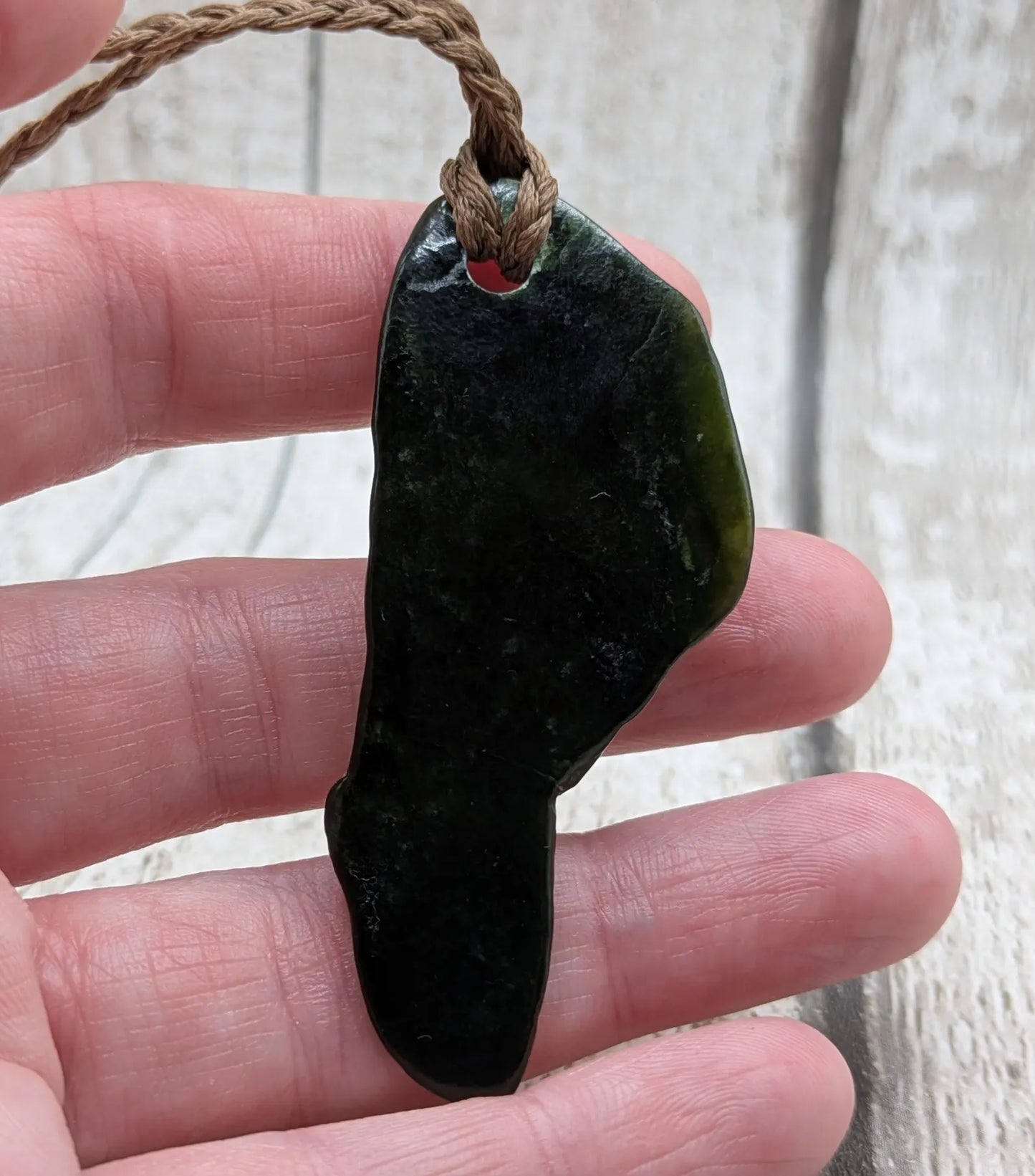 Tumble polished New Zealand greenstone jade pendant.