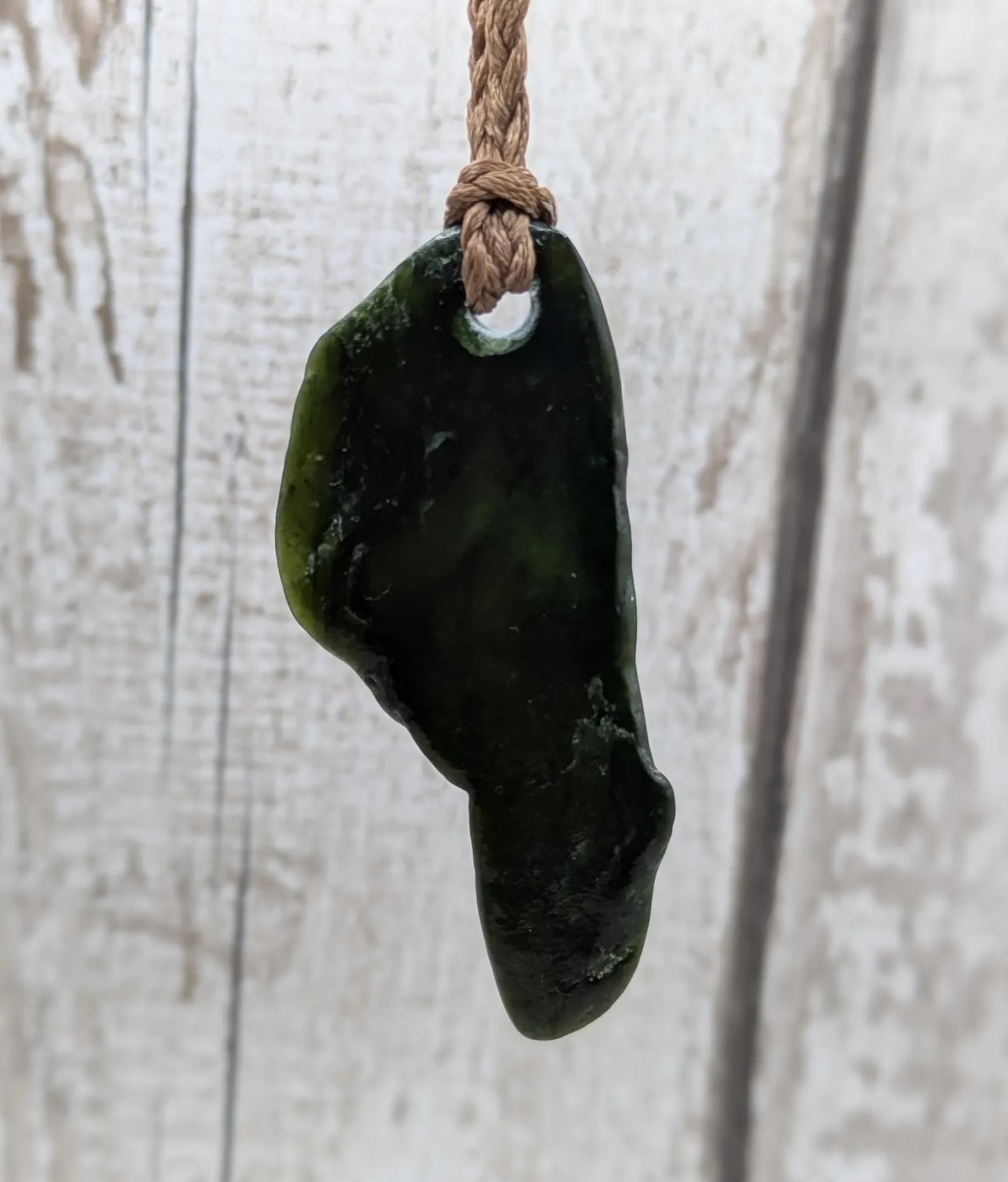 Tumble polished New Zealand greenstone jade pendant.