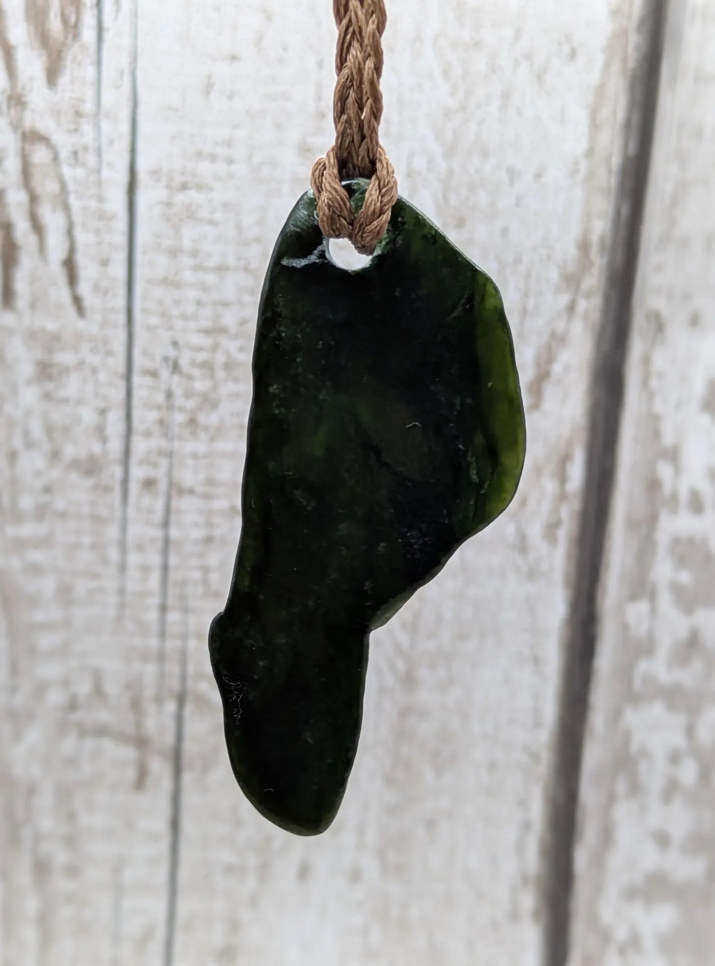 Tumble polished New Zealand greenstone jade pendant.