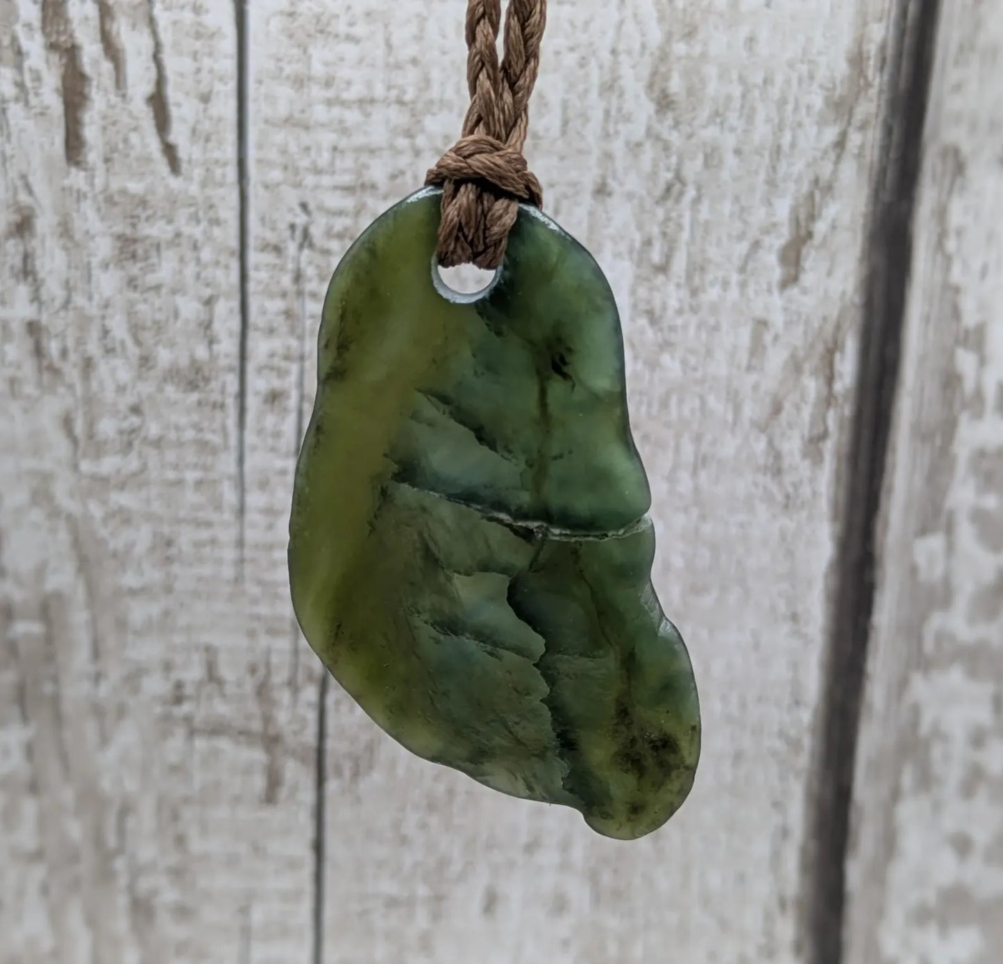 Tumbled polished New Zealand greenstone Pounamu jade pendant.
