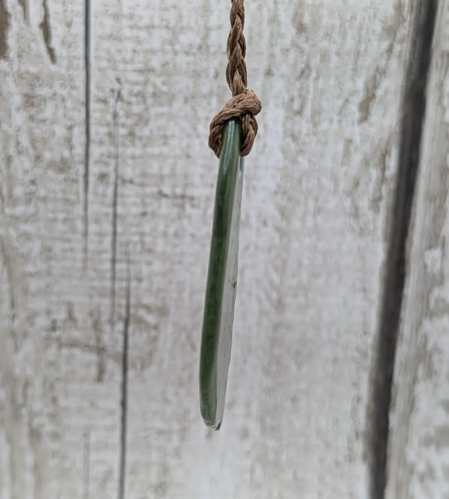 Tumbled polished New Zealand greenstone Pounamu jade pendant.