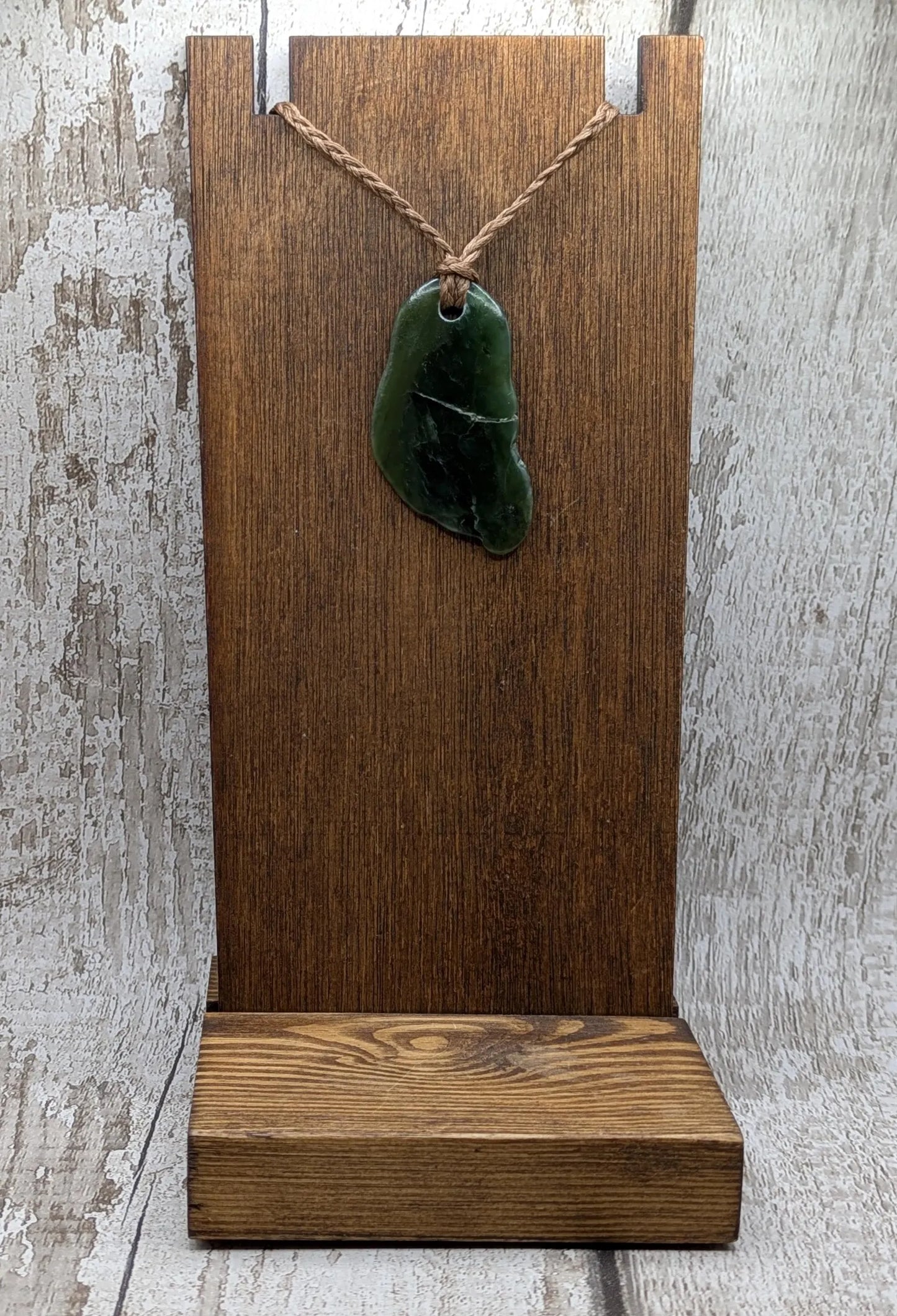 Tumbled polished New Zealand greenstone Pounamu jade pendant.