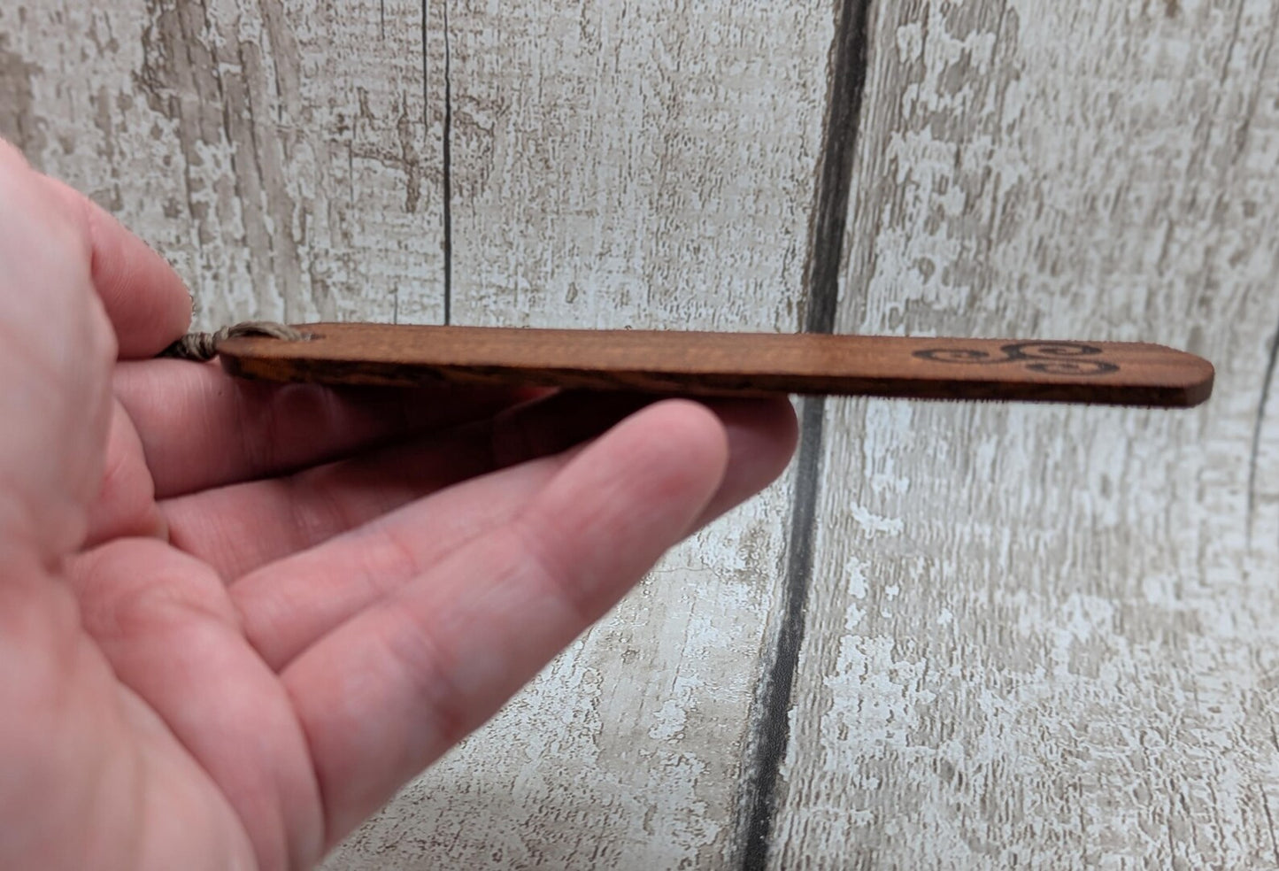 Walnut wood hand made bookmark with triskele laser print.