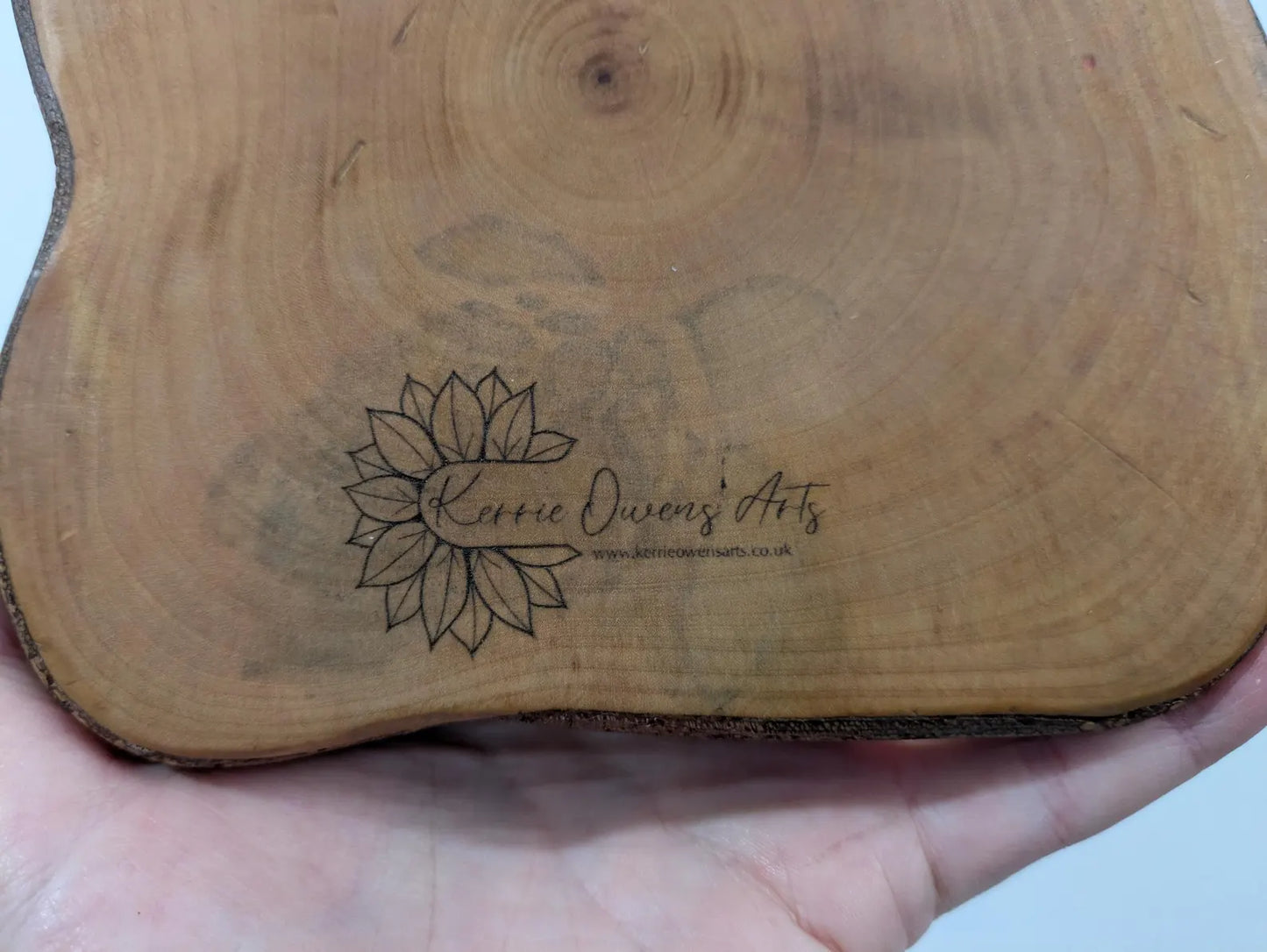 Wooden tree slice dowsing board with geometric laser print design, incense stick holder and loose abalone shell for crystals and herbs.