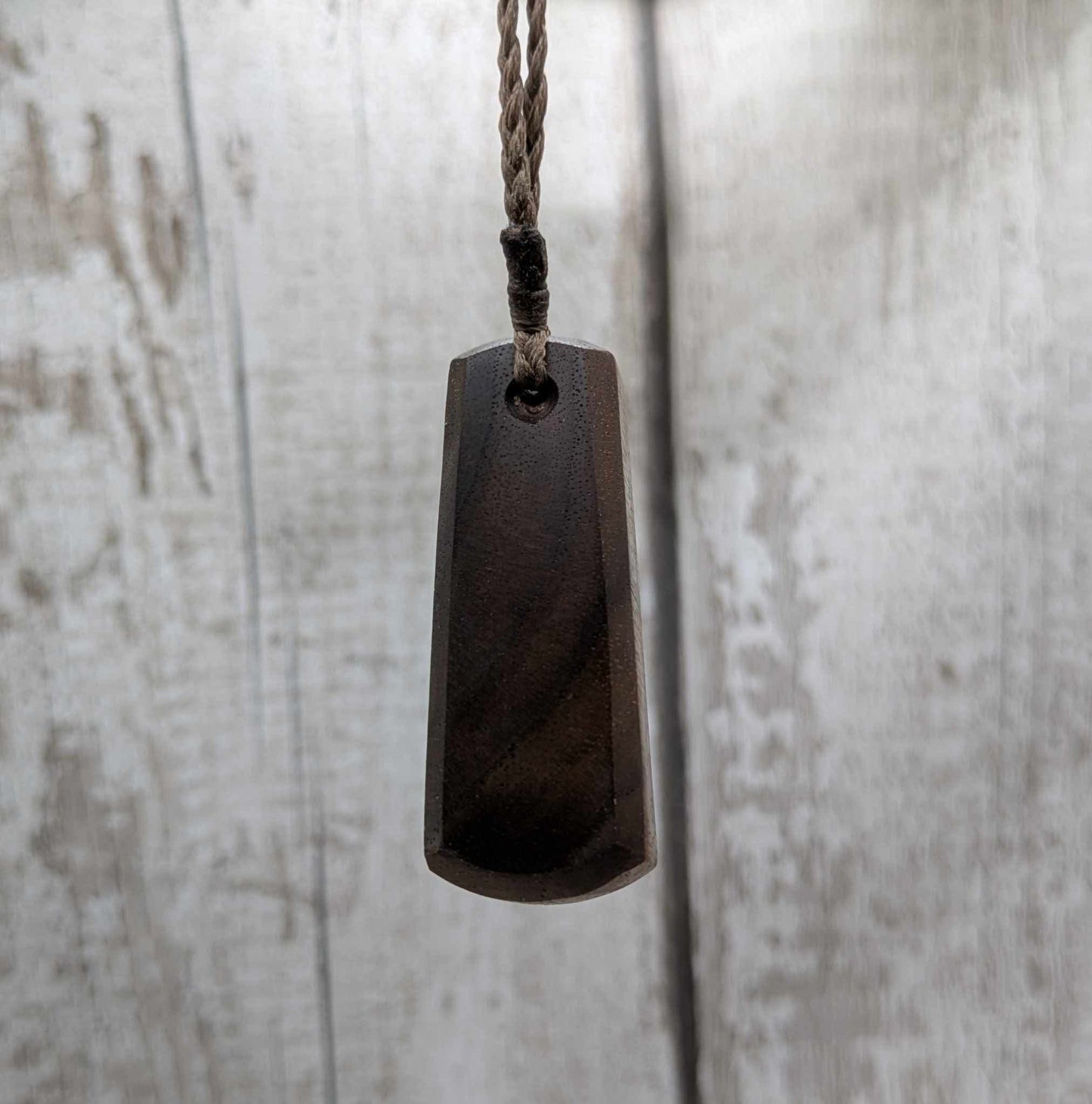 Walnut wood pendant with mussel shell inlay.