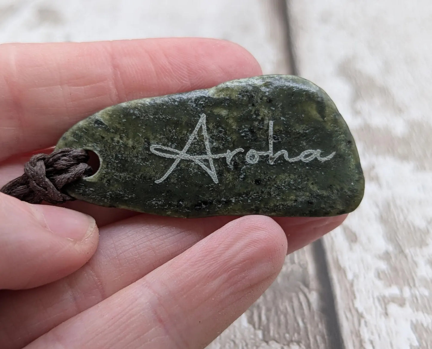 Nz tumble polished Pounamu jade pendant with Aroha love affirmation.