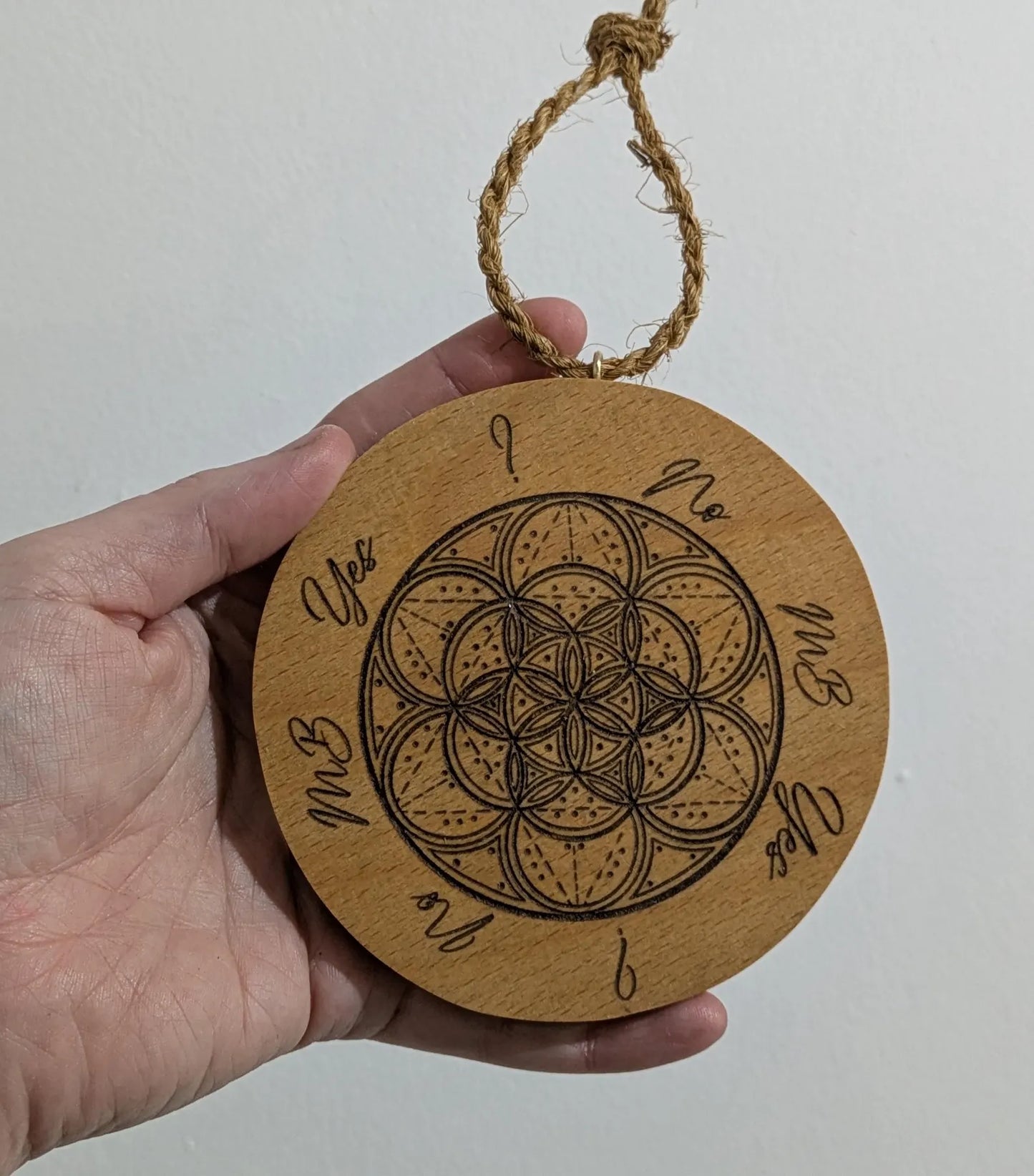 Recycled ply wood pendulum dowsing board with geometric design.